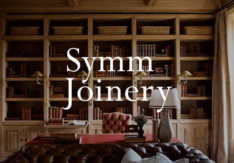 A living room with a couch and bookshelves and the words symm joinery