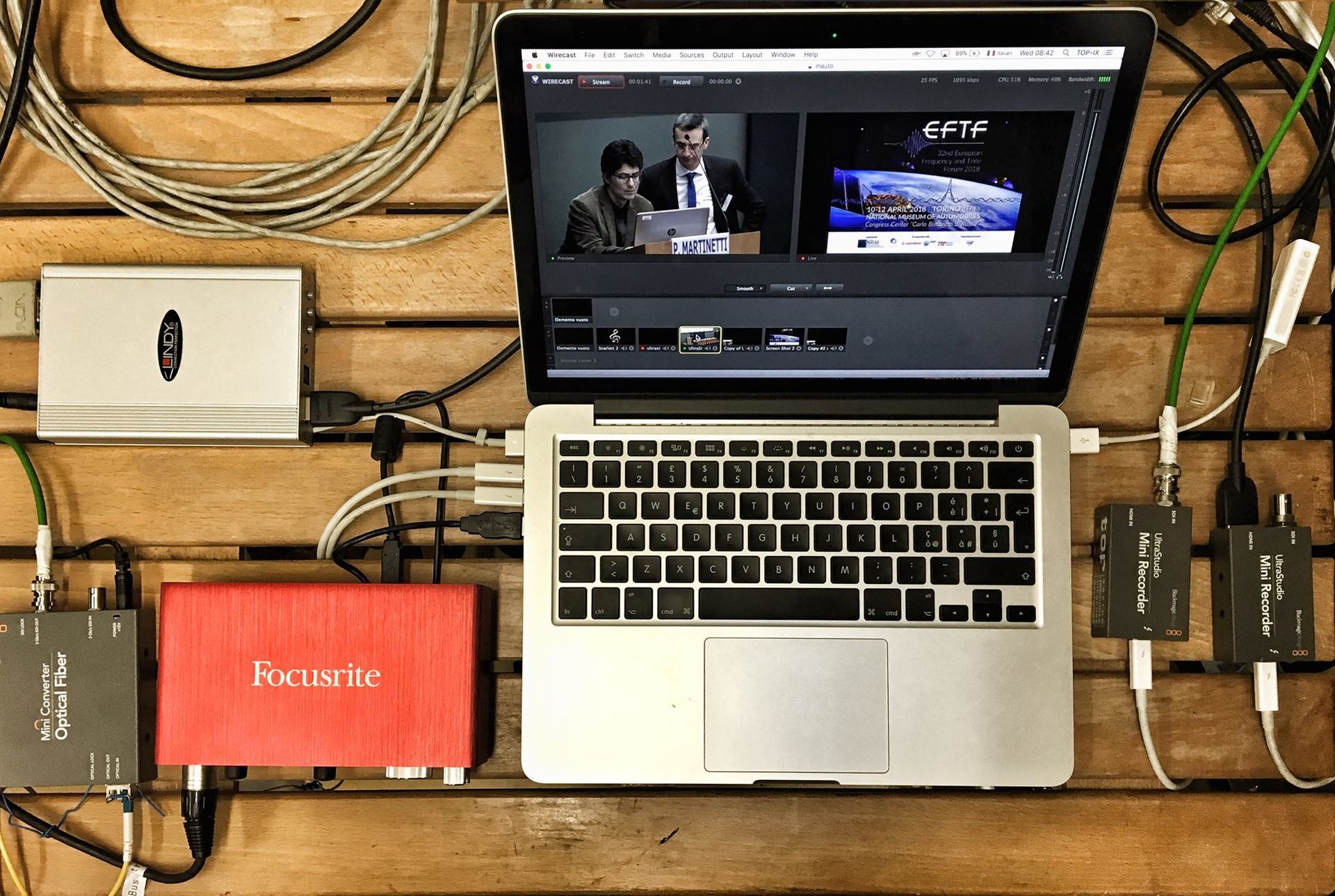 Computer portatile con software di editing collegato ai dispositivi tramite cavi, che mostra l'anteprima video.