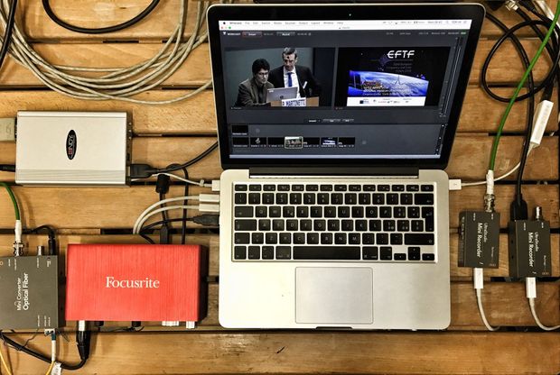 Computer portatile con software di editing collegato ai dispositivi tramite cavi, che mostra l'anteprima video.