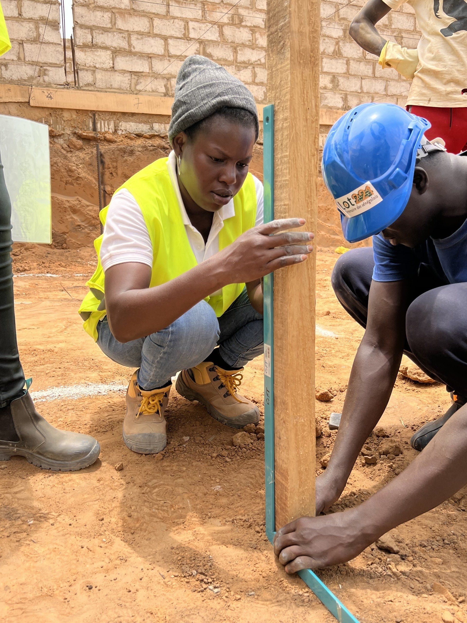 Un homme et une femme mesurent un poteau en bois.
