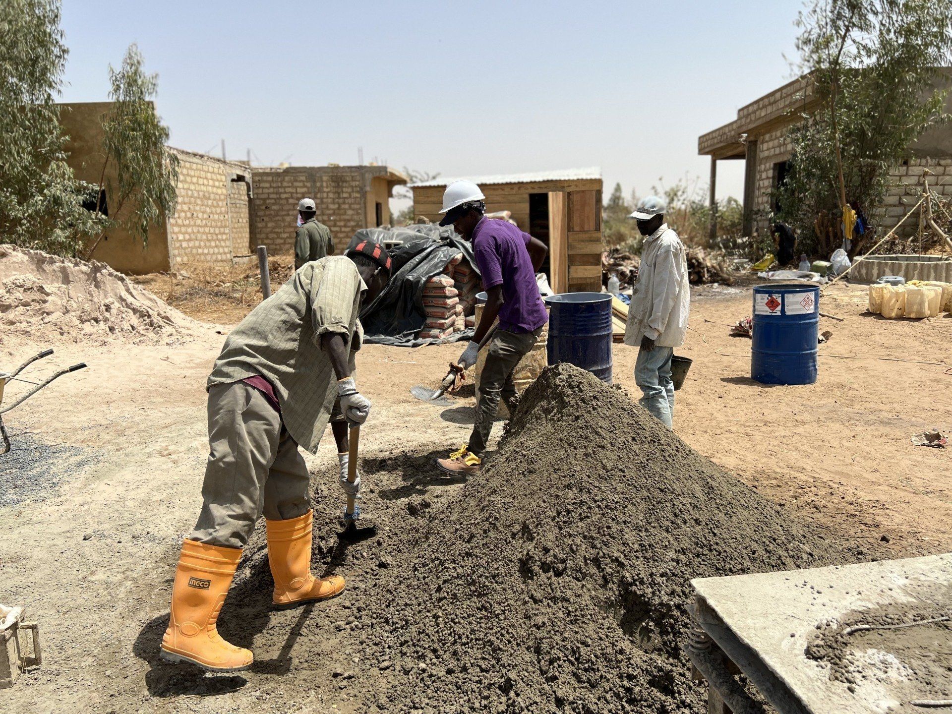 Un groupe d'ouvriers du bâtiment travaillent sur un tas de terre.
