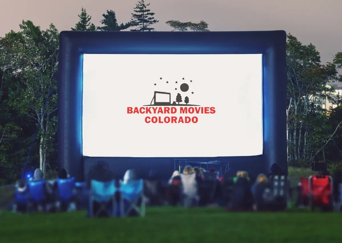 An inflatable movie screen rental set up in a backyard in Denver, CO with a screen that says welcome to movie night.