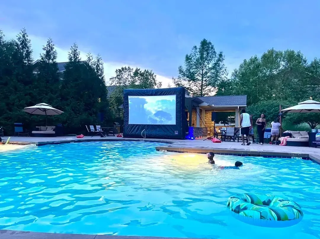 A large inflatable screen is in the middle of a swimming pool.