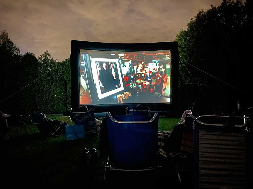 A large inflatable screen with a picture of a group of people on it and a family in their yard in Colorado Springs, CO