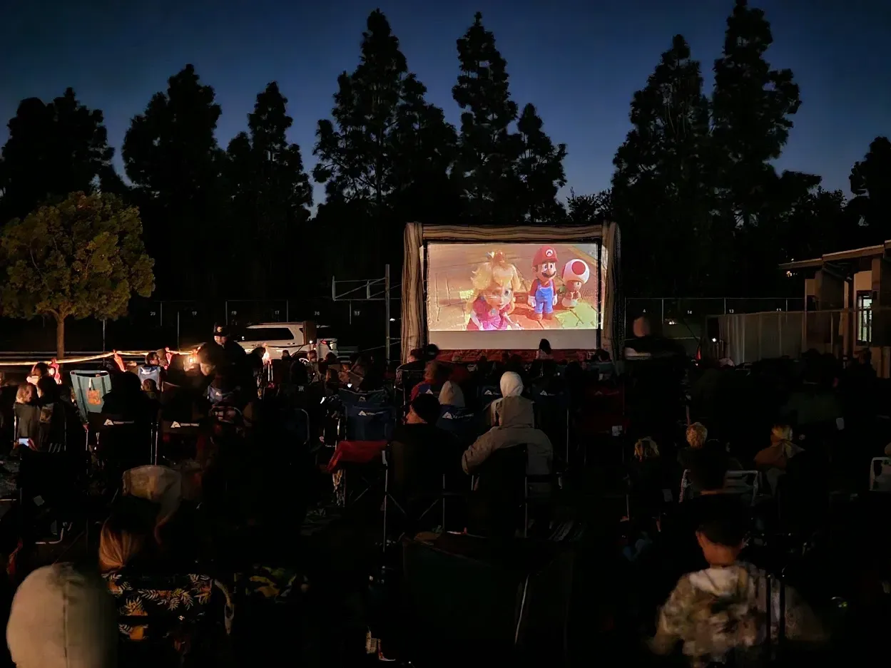 A group of people are watching a movie on a large screen