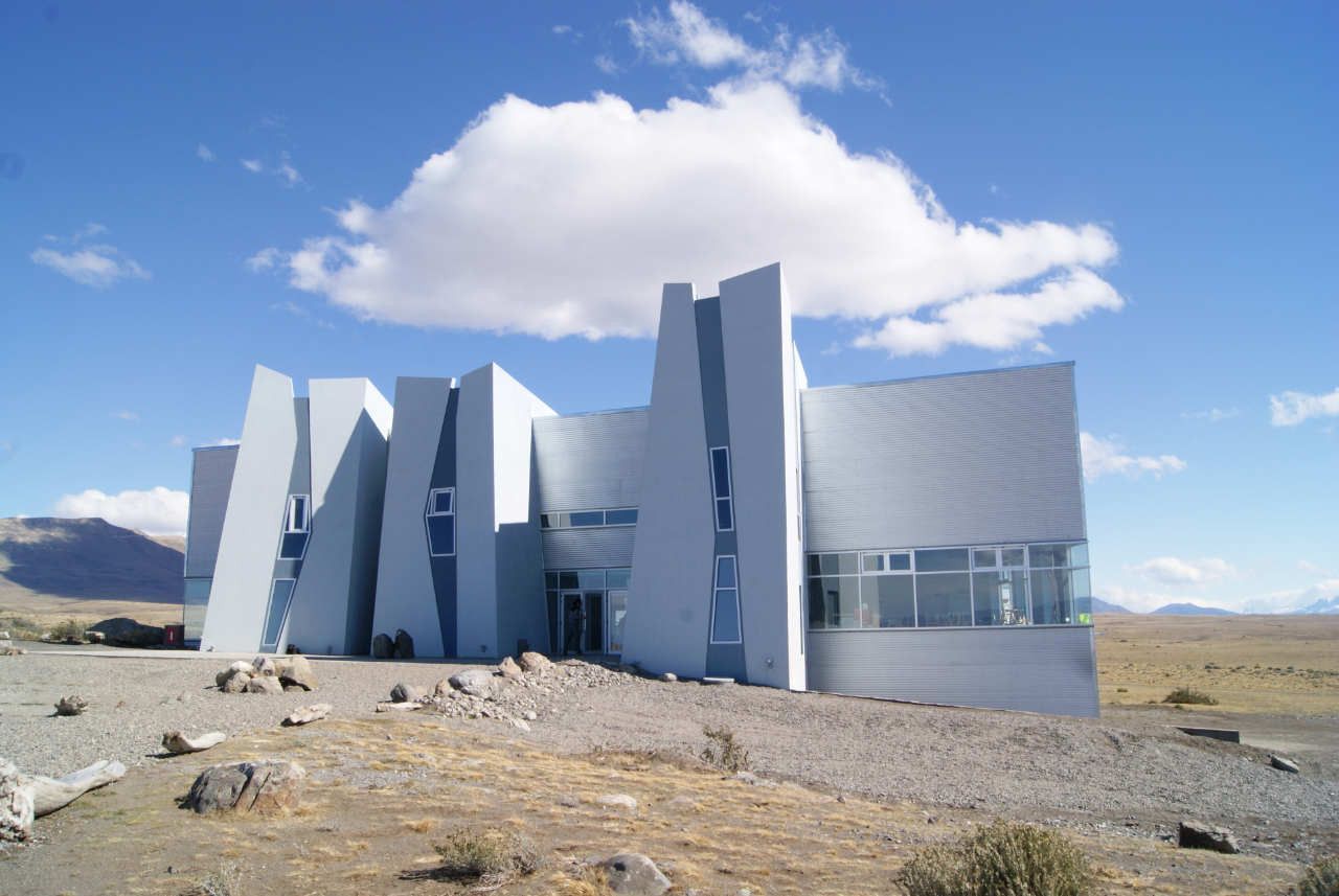 Un gran edificio blanco con un cielo azul y nubes detrás