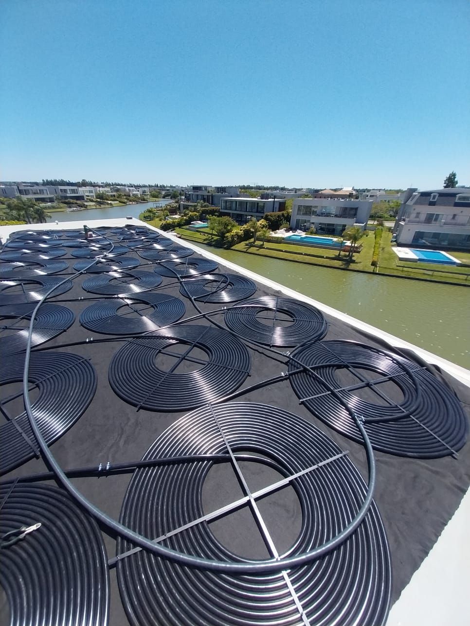 Un techo con muchos paneles solares y una piscina al fondo.