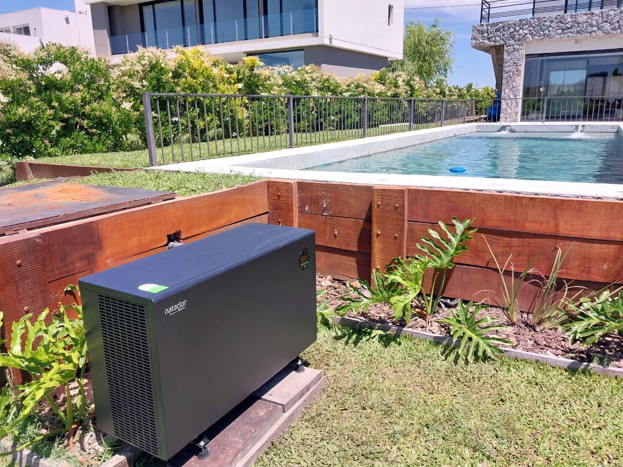 Una caja negra está en el césped al lado de una piscina.