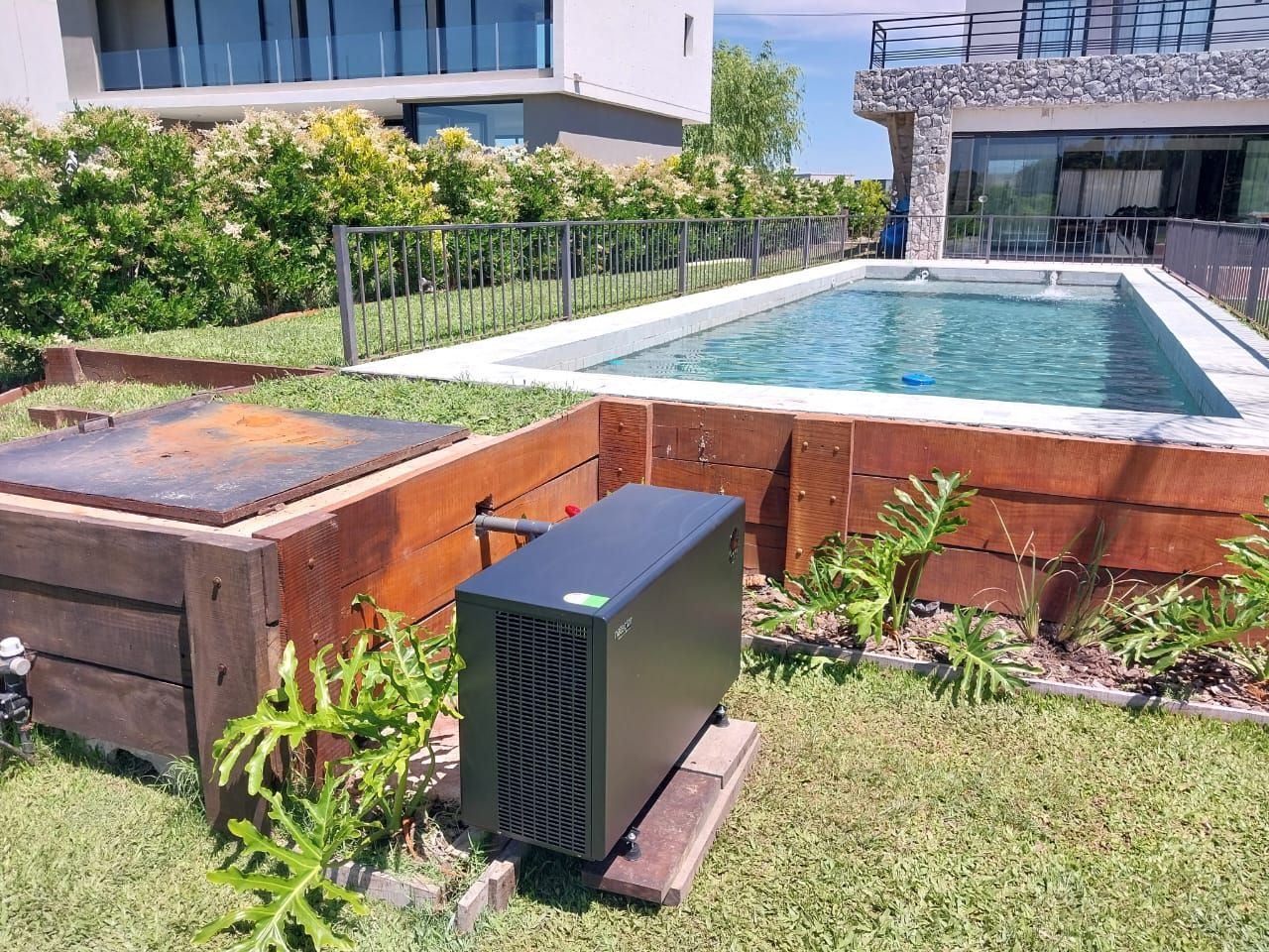 Una caja negra está en el césped al lado de una piscina.