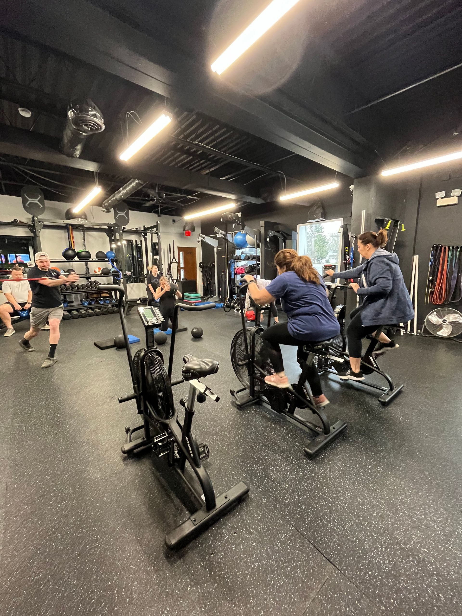 A group of people are riding exercise bikes in a gym.