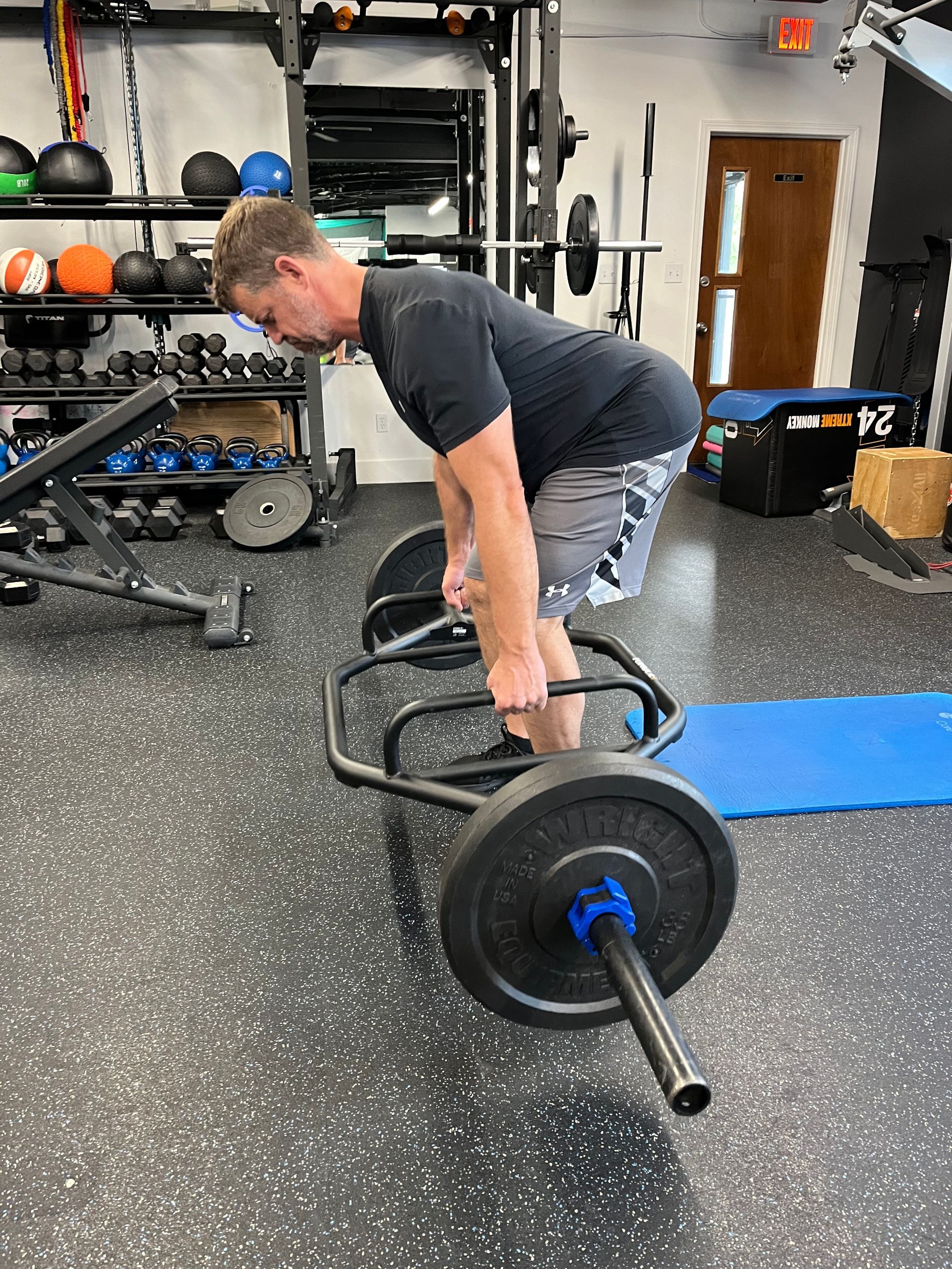 A man is lifting a barbell in a gym.
