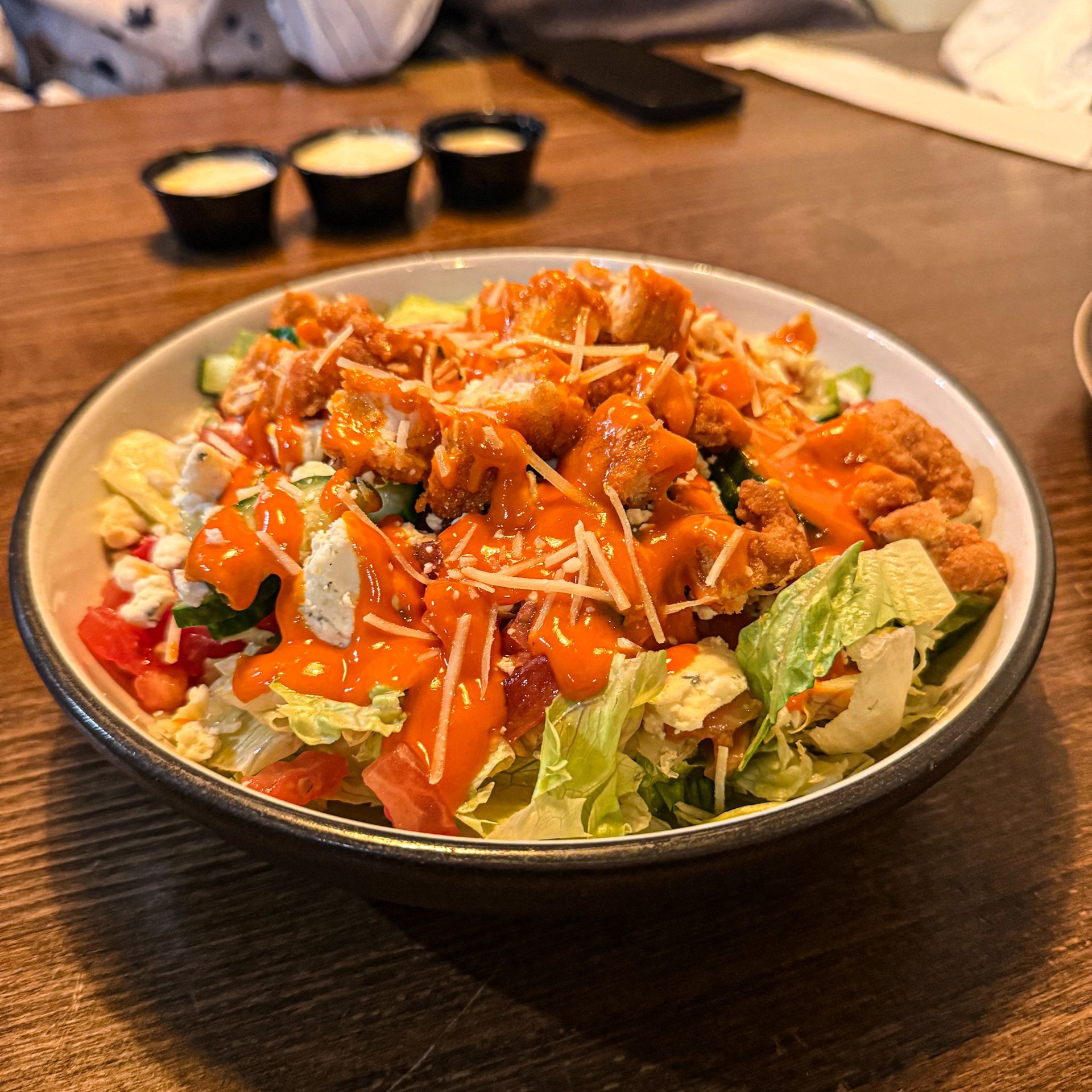 A salad with chicken and vegetables on a plate on a table.