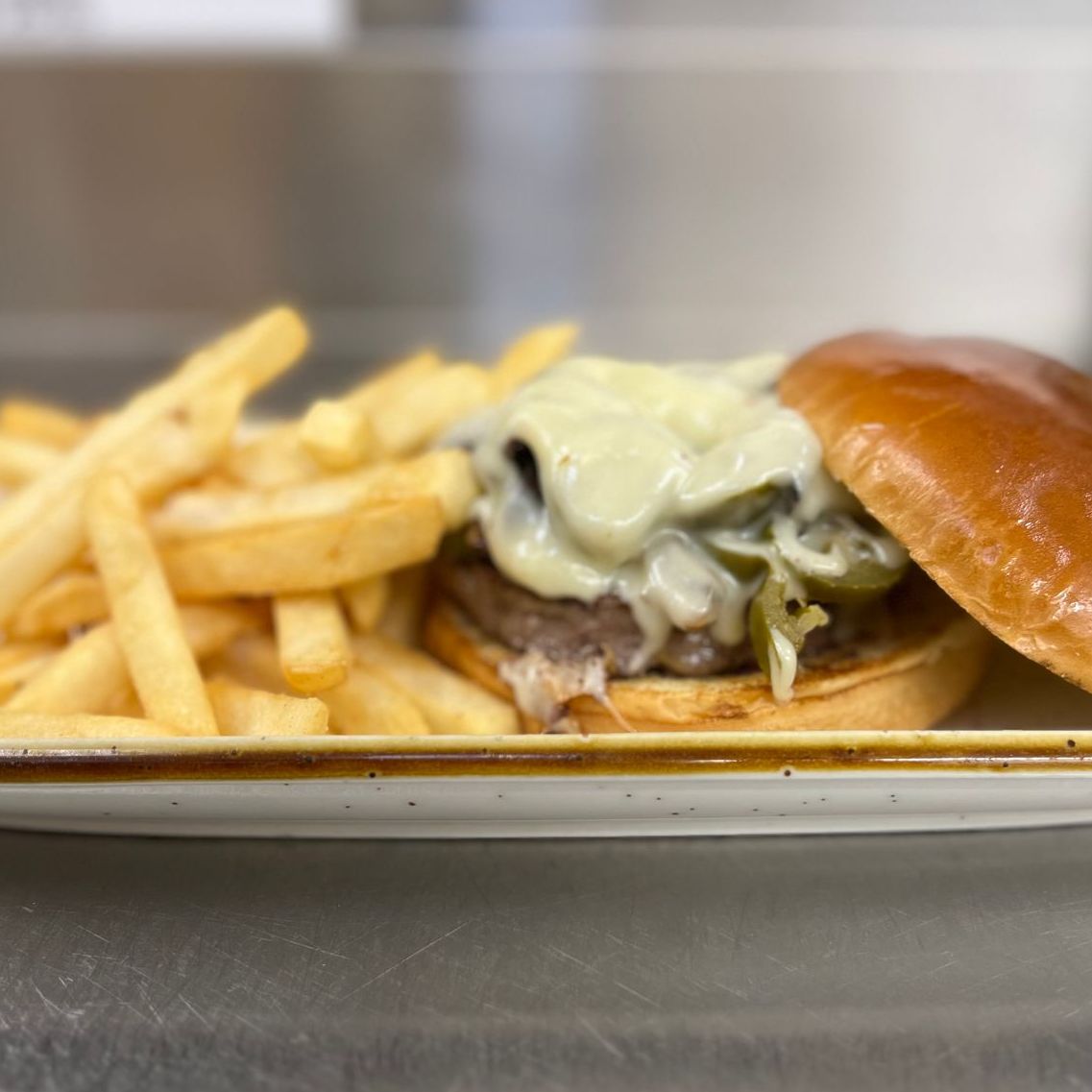 A sandwich with french fries and coleslaw on a plate on a table.