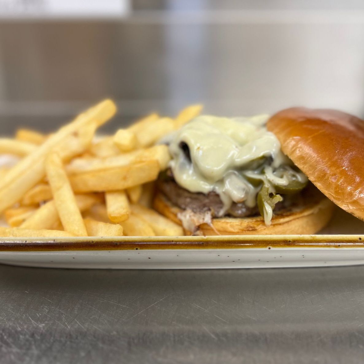 A sandwich and french fries on a plate on a table.