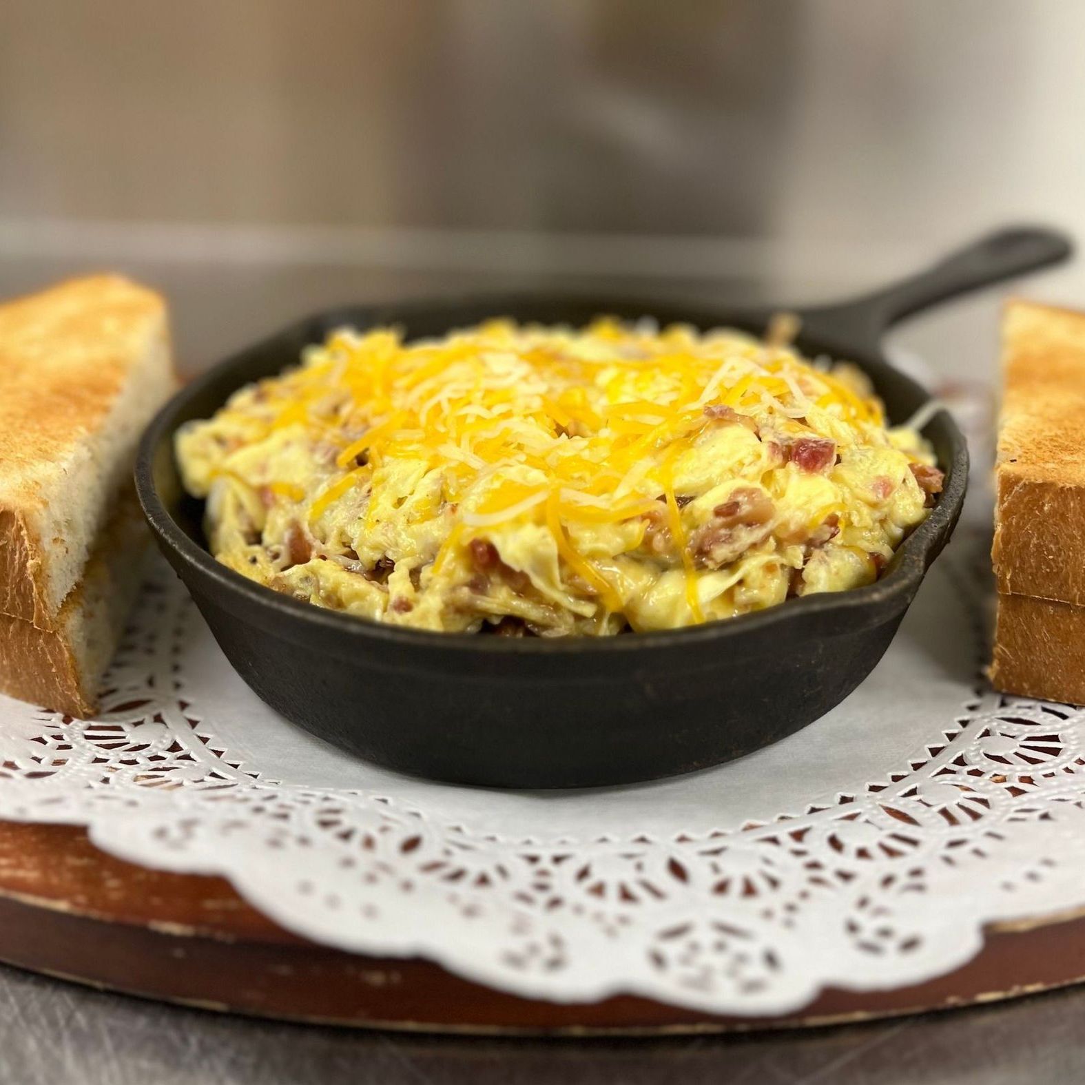There is a plate of french toast and eggs on the table.