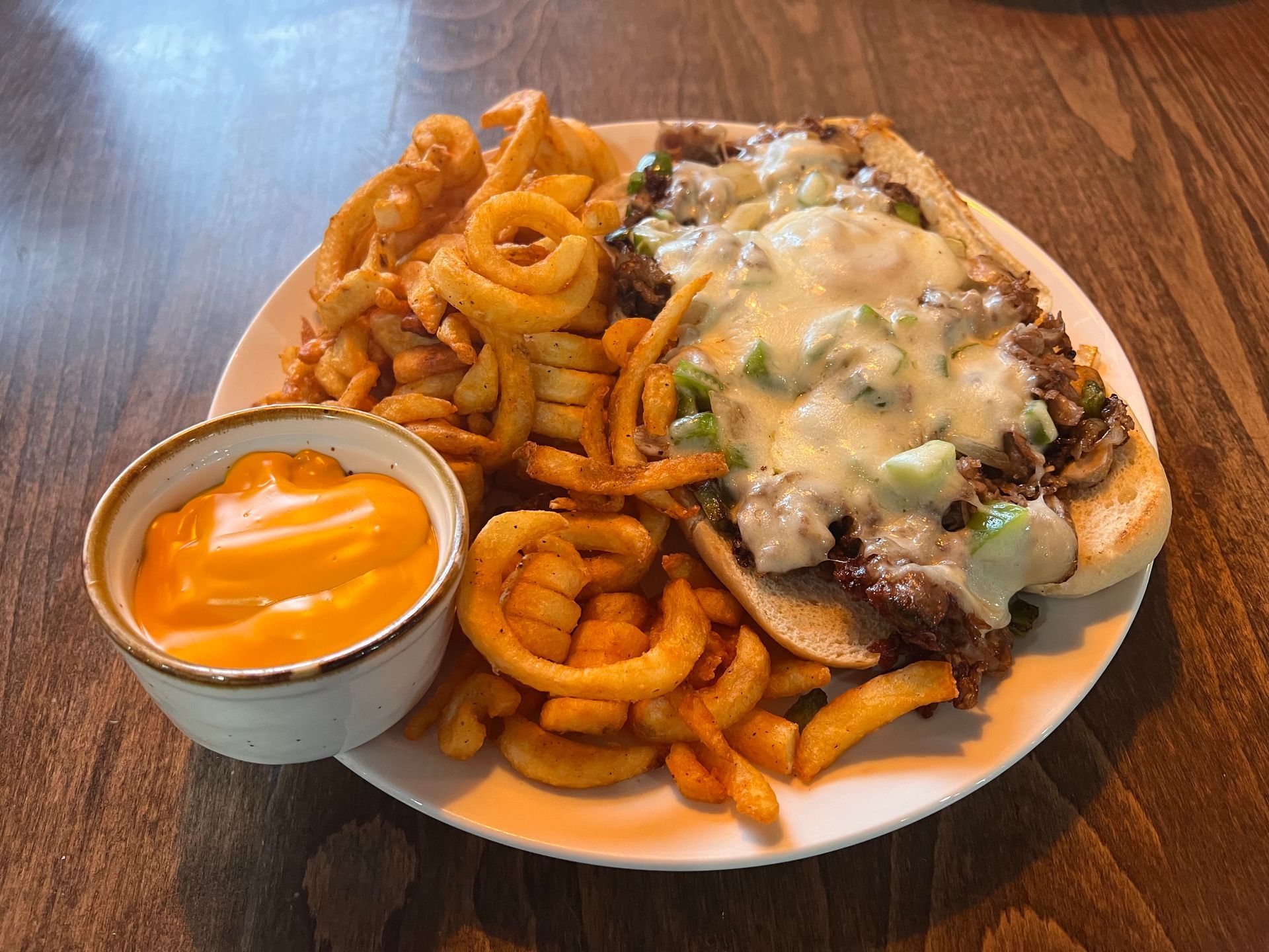 A sandwich and french fries on a plate on a table.