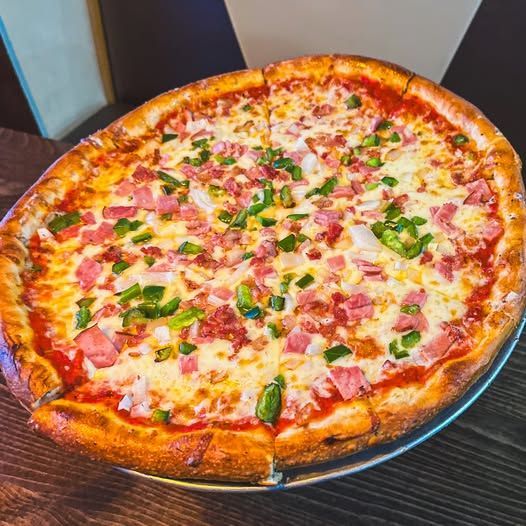 A pizza with pepperoni , olives , mushrooms and cheese is in a box.