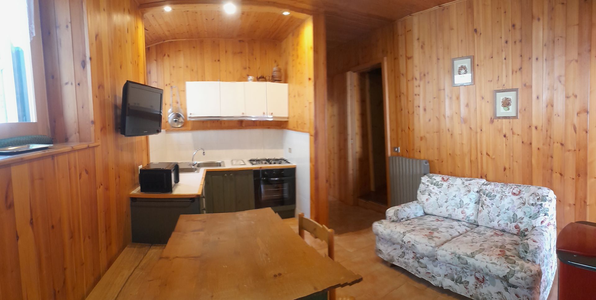 Un soggiorno con divano, tavolo e televisione.