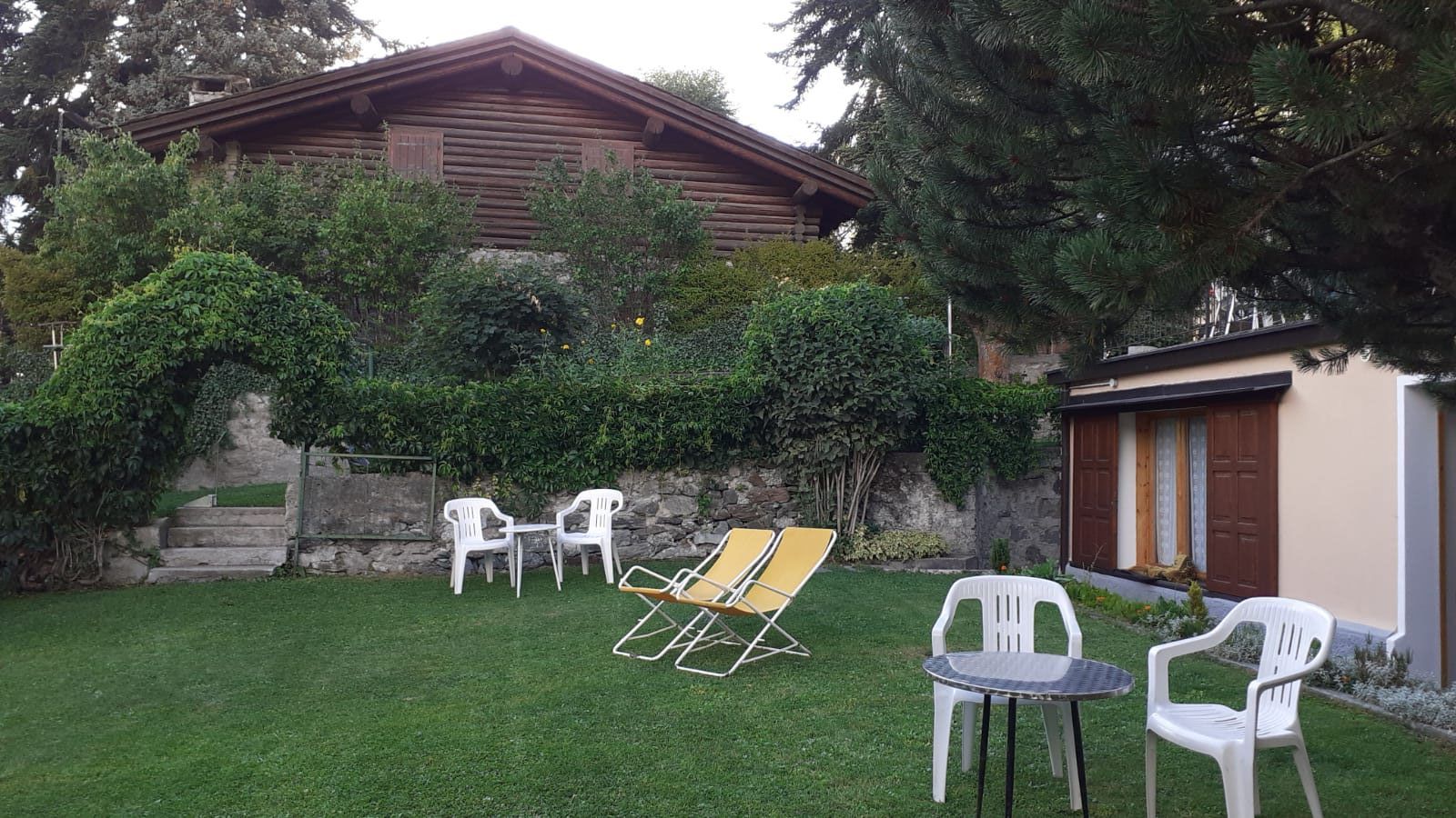 Un prato con sedie e un tavolo davanti a una casa