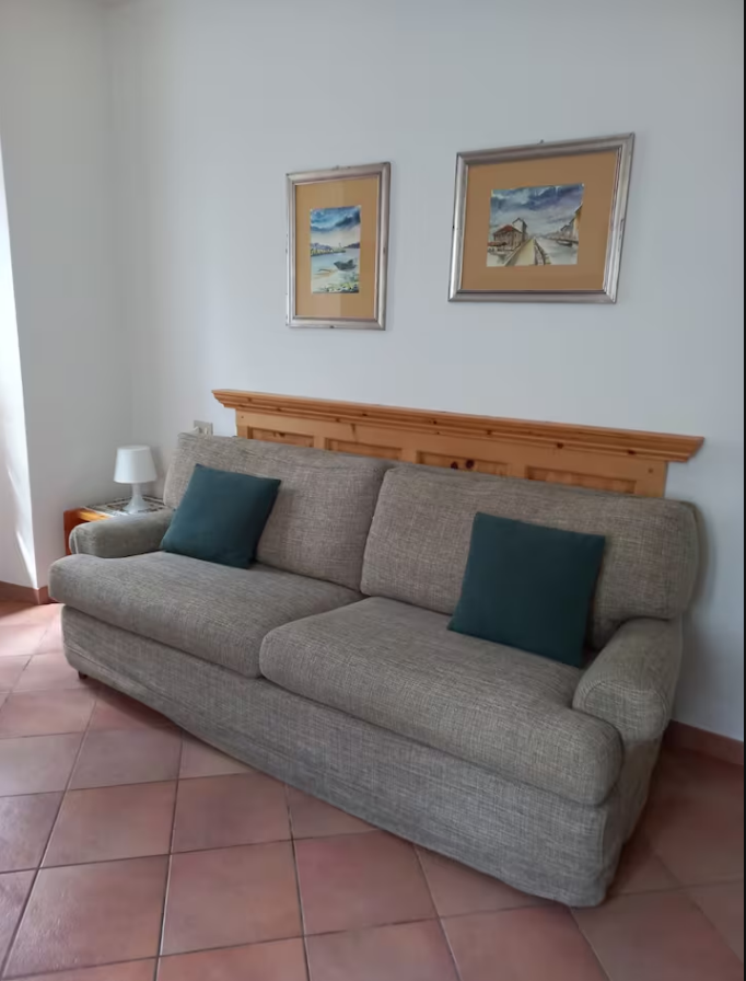 Un soggiorno con un divano e due quadri sul muro