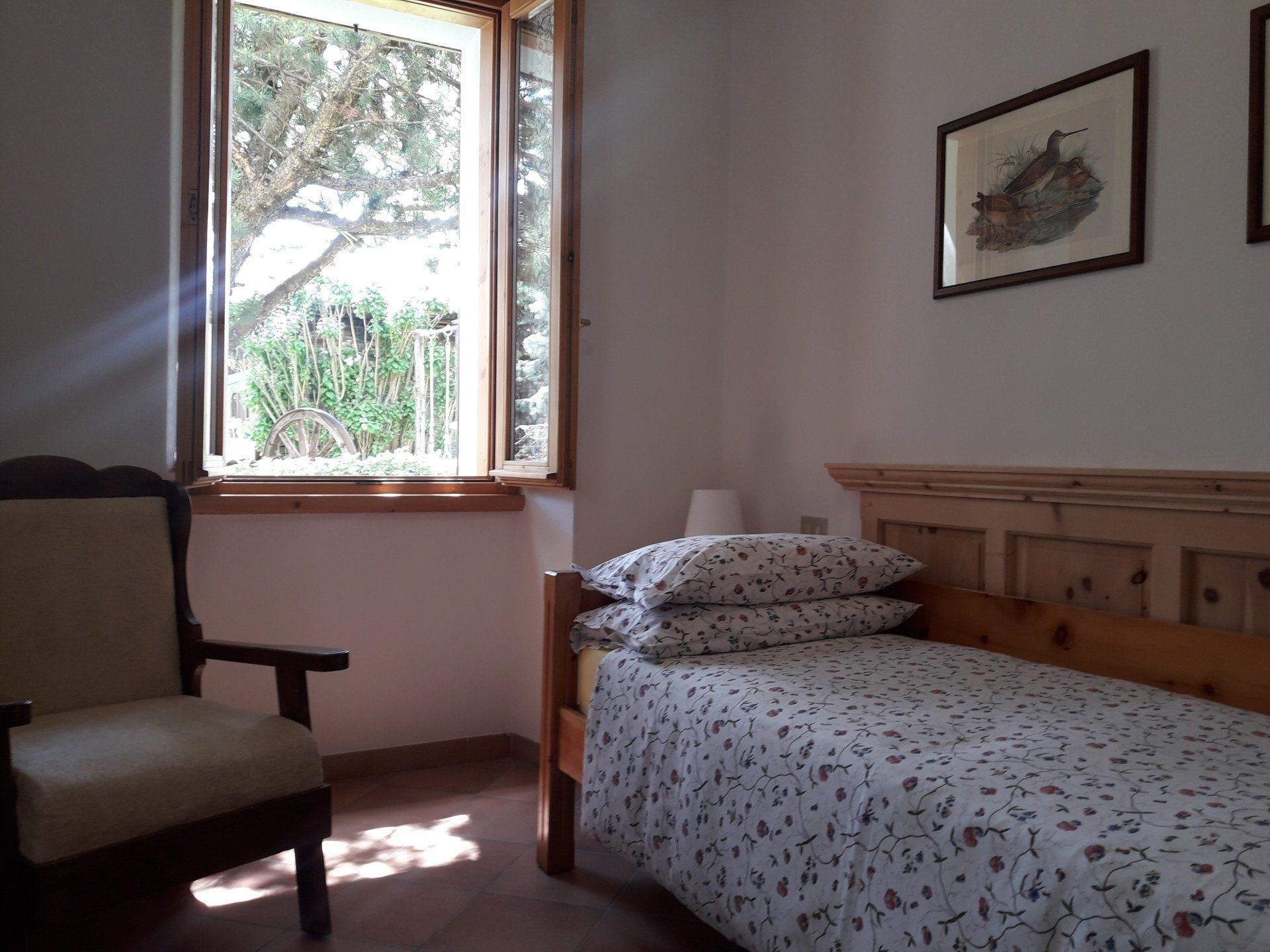 Una camera da letto con un letto singolo e una sedia