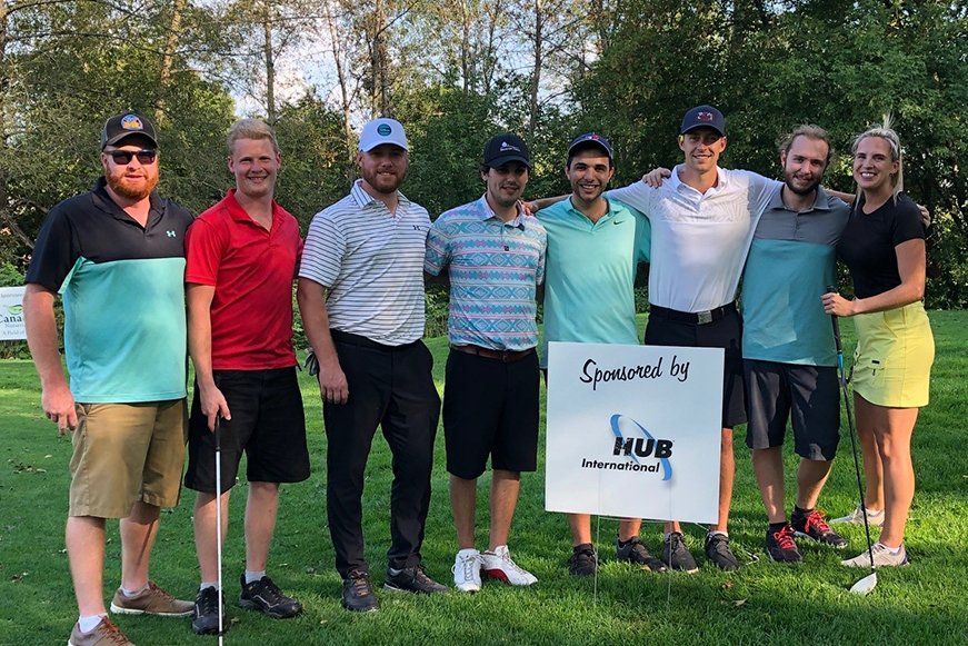 A group of people are posing for a picture on a golf course.
