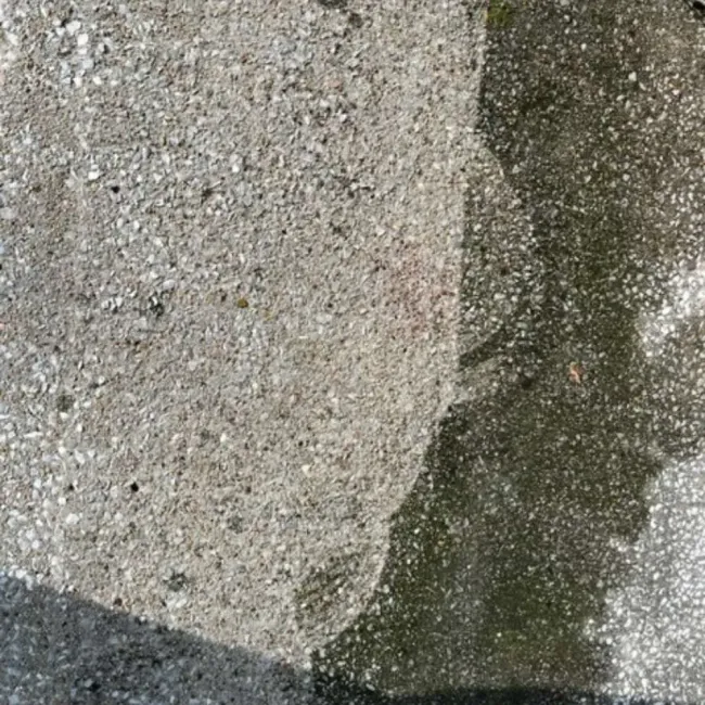 A close up of a concrete surface with a shadow of a person on it.