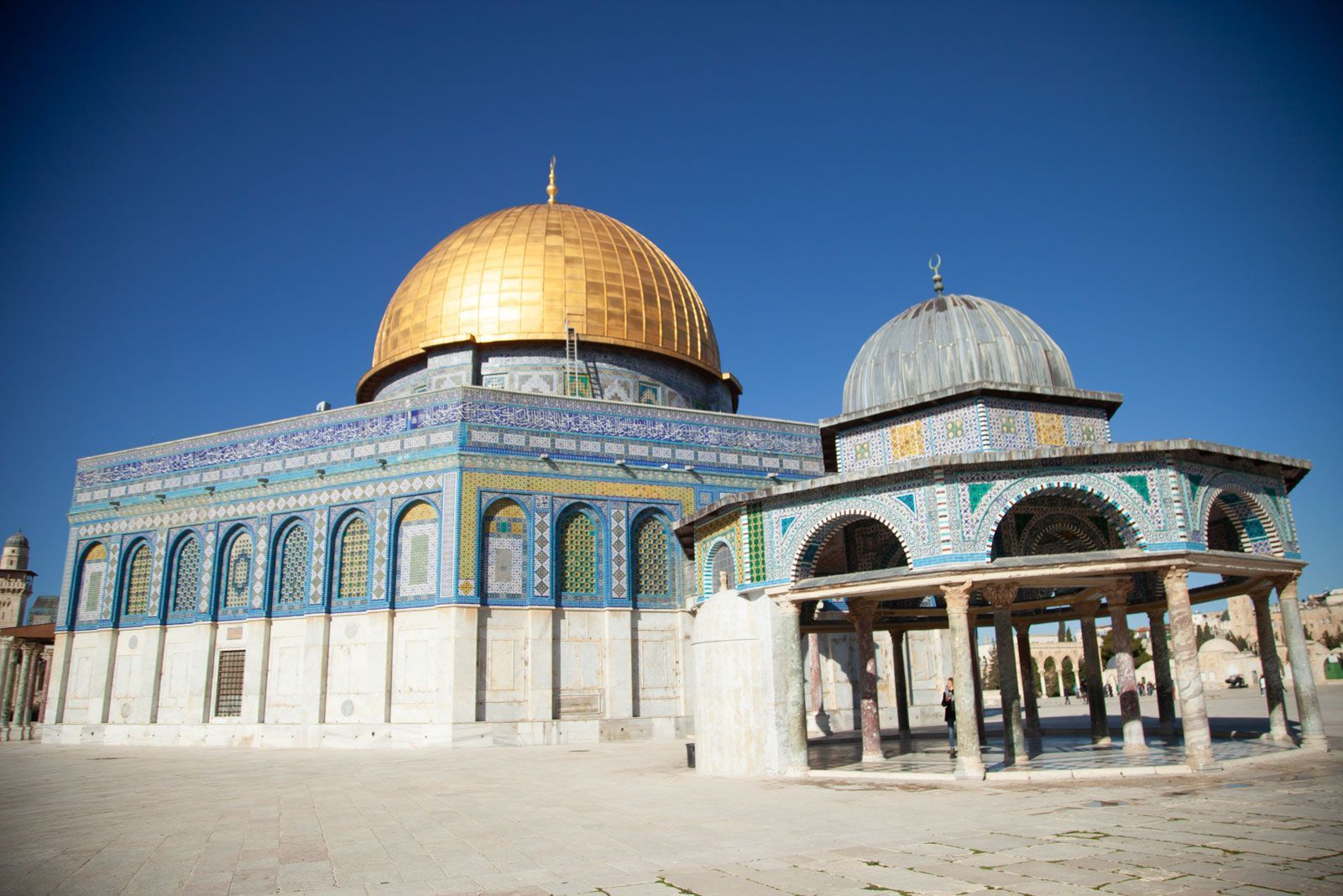 Dome of the Rock, Jerusalem, with gold dome and turquoise tile facade under a blue sky.
