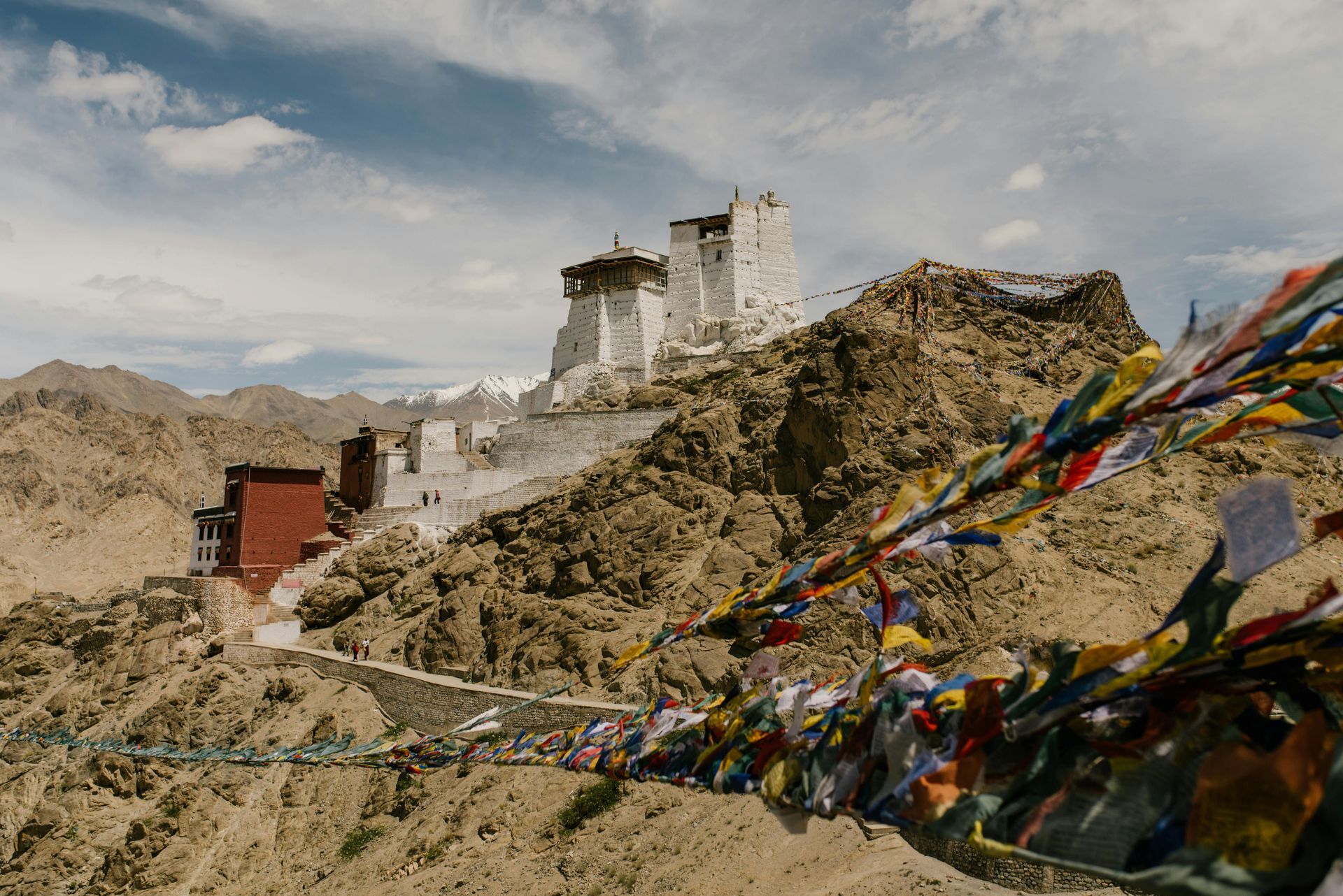 White castle on rocky mountain with prayer flags.