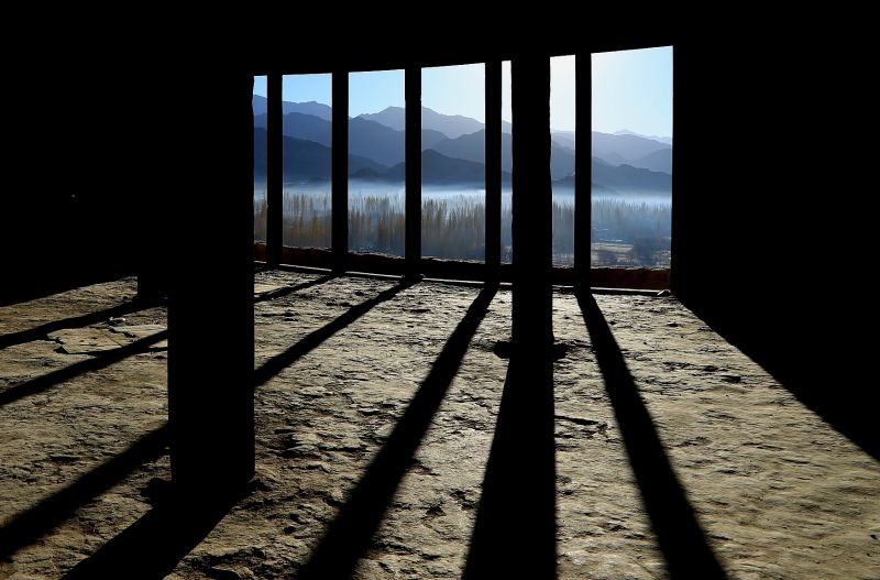 Interior view through window with shadows and mountains.