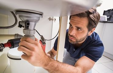 Plumber fixing kitchen sink