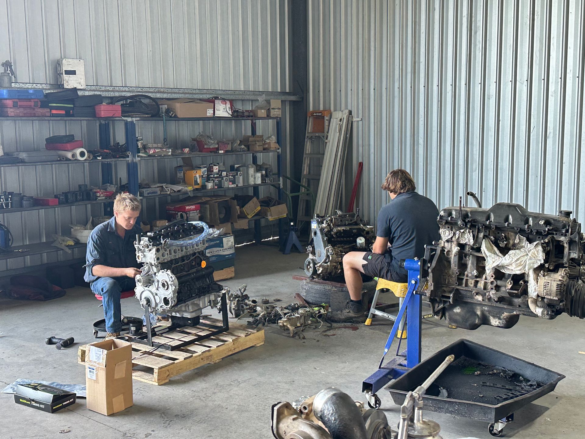 A Man is Working on a Red Tractor in a Garage — Burmec In Narrabri, NSW