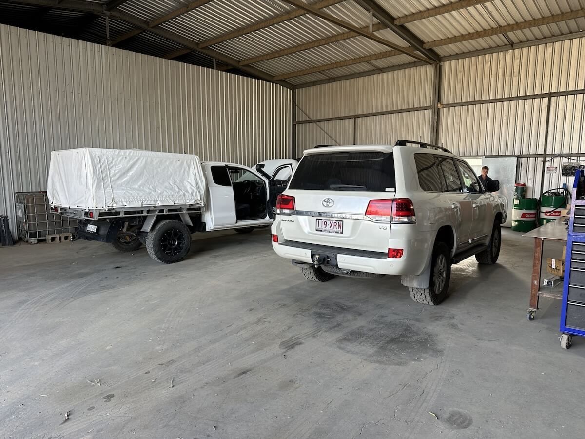 A white suv is parked in a garage next to a white truck — Burmec In Narrabri, NSW