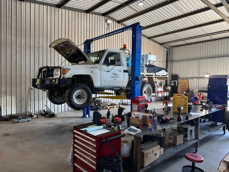 A White Truck is Sitting on a Lift in a Garage — Burmec In Narrabri, NSW