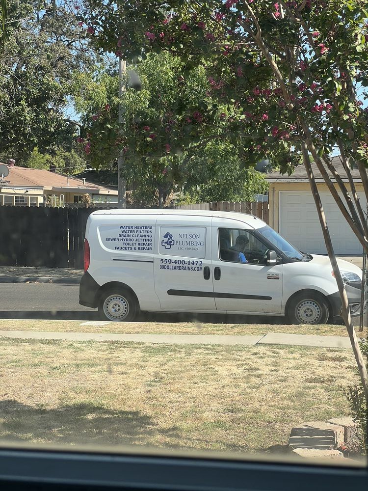 White service van parked on a residential street under trees, with houses in the background.