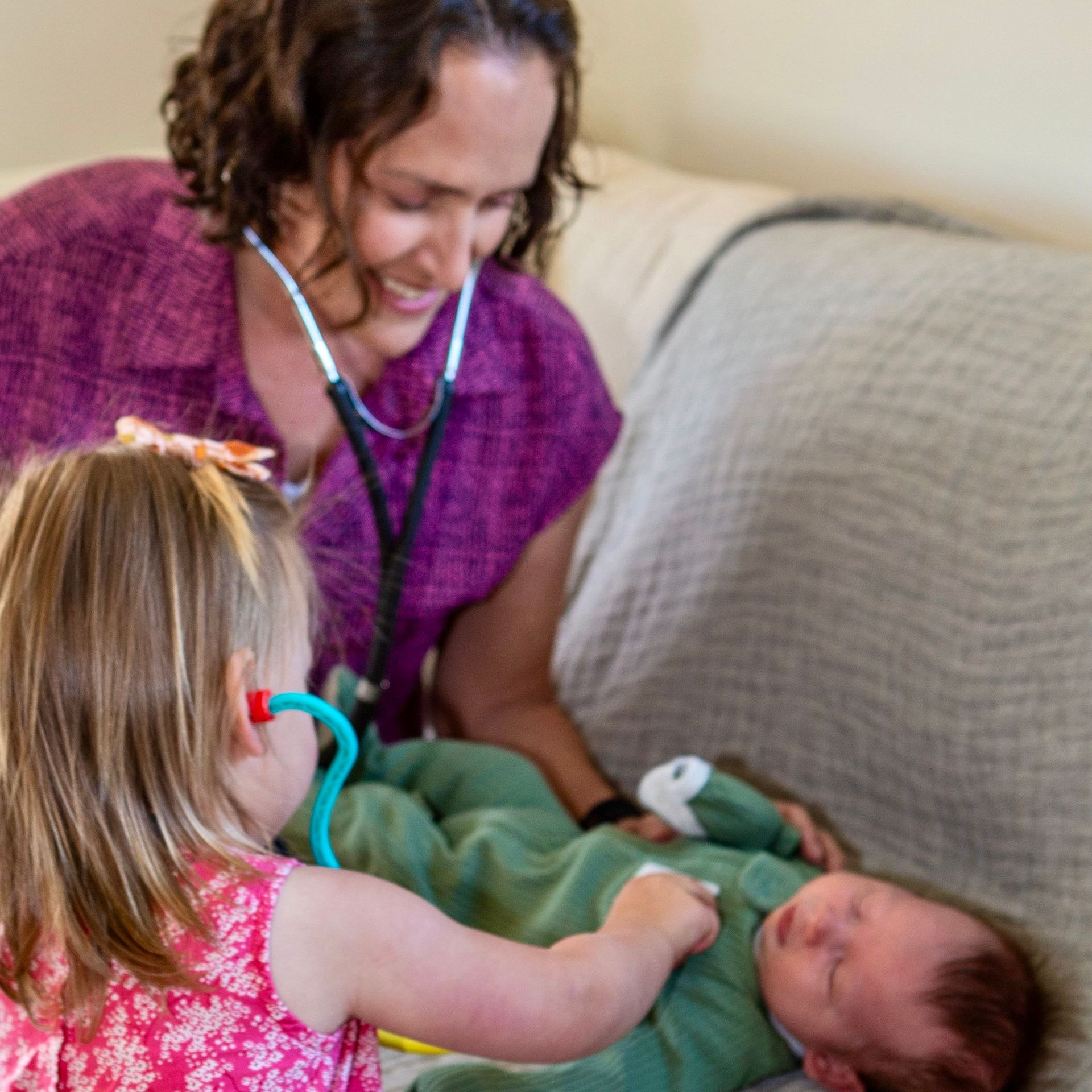A little girl is listening to a baby 's heartbeat with a stethoscope