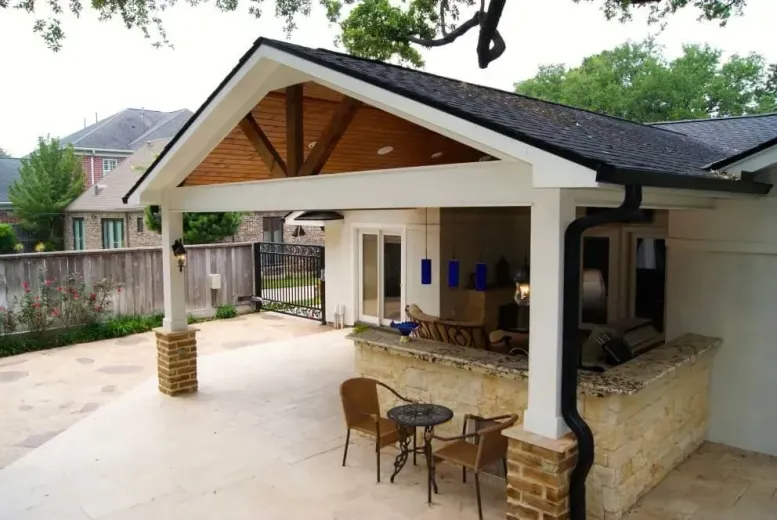 A patio with a table and chairs under a roof