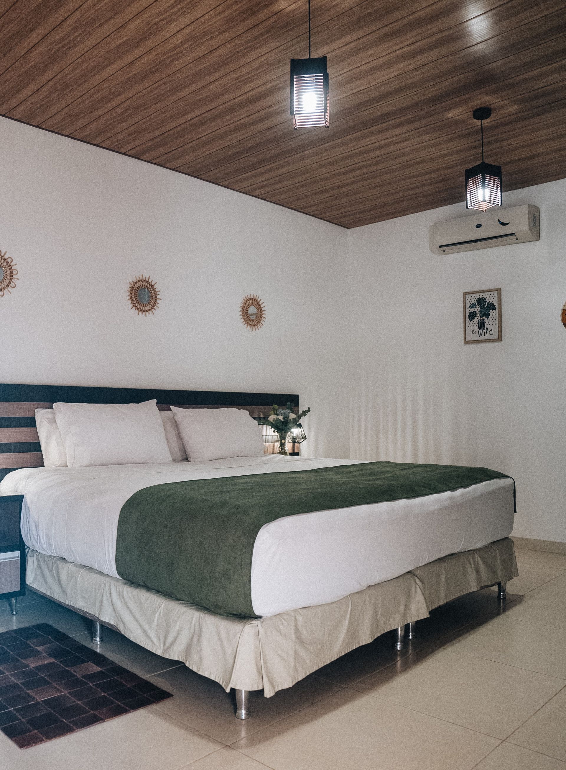 Un dormitorio con una cama grande y una lámpara en la mesita de noche.