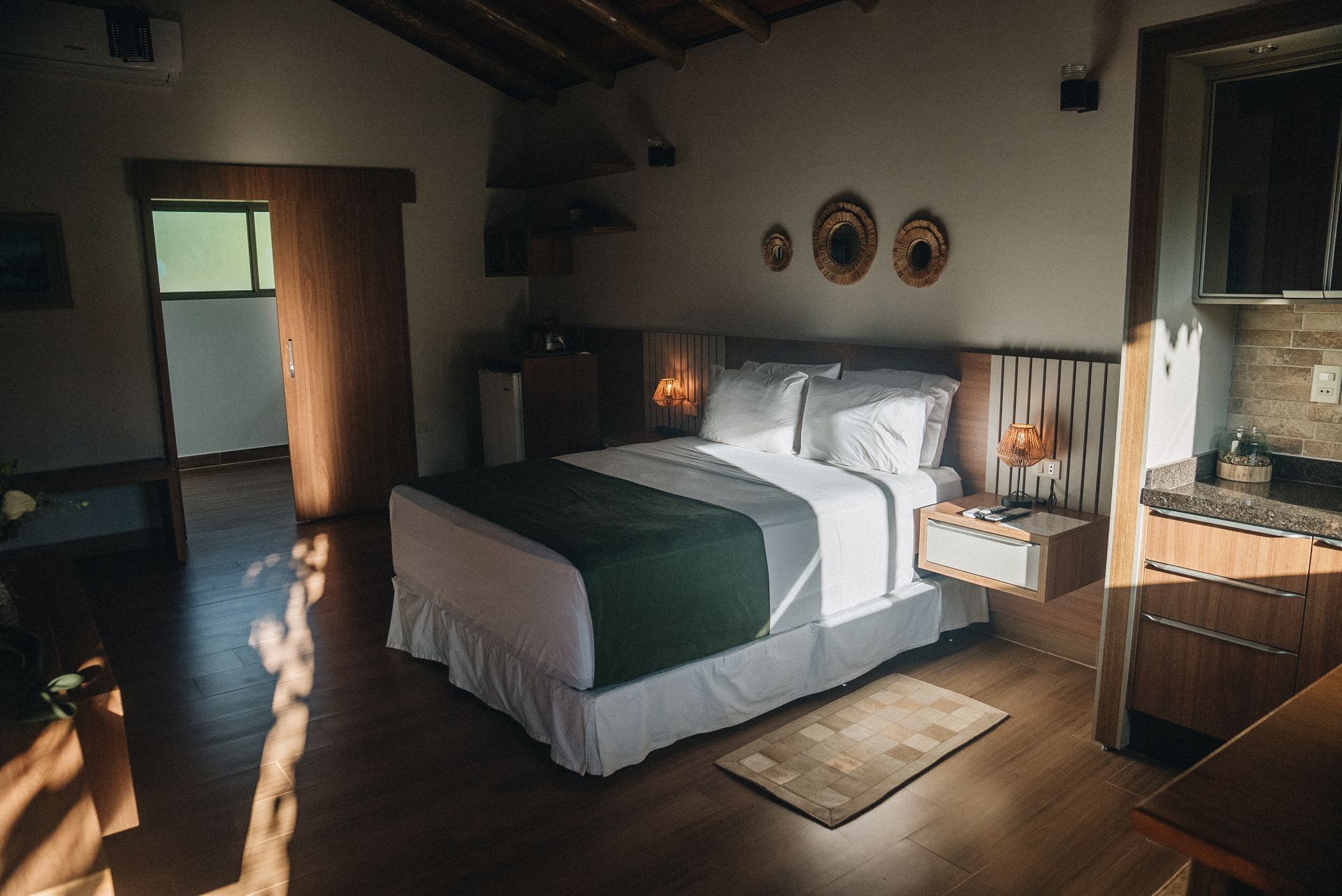 Una pequeña casa blanca está rodeada de césped y árboles.