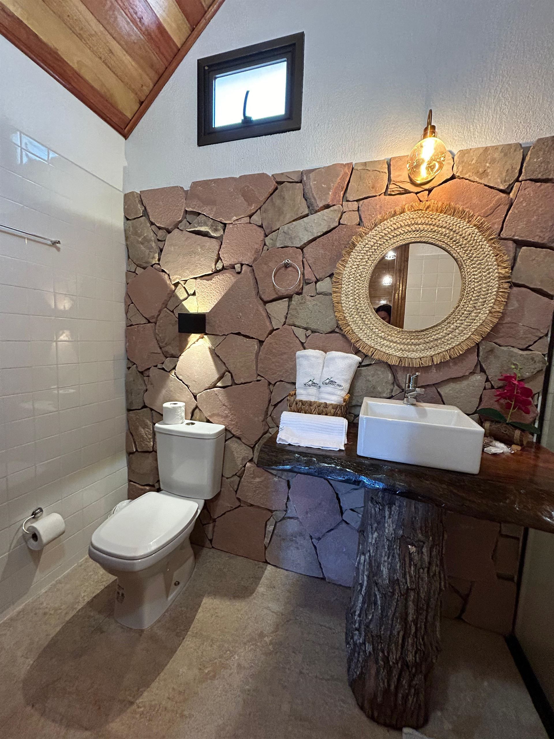 Un baño con inodoro, lavabo y espejo.