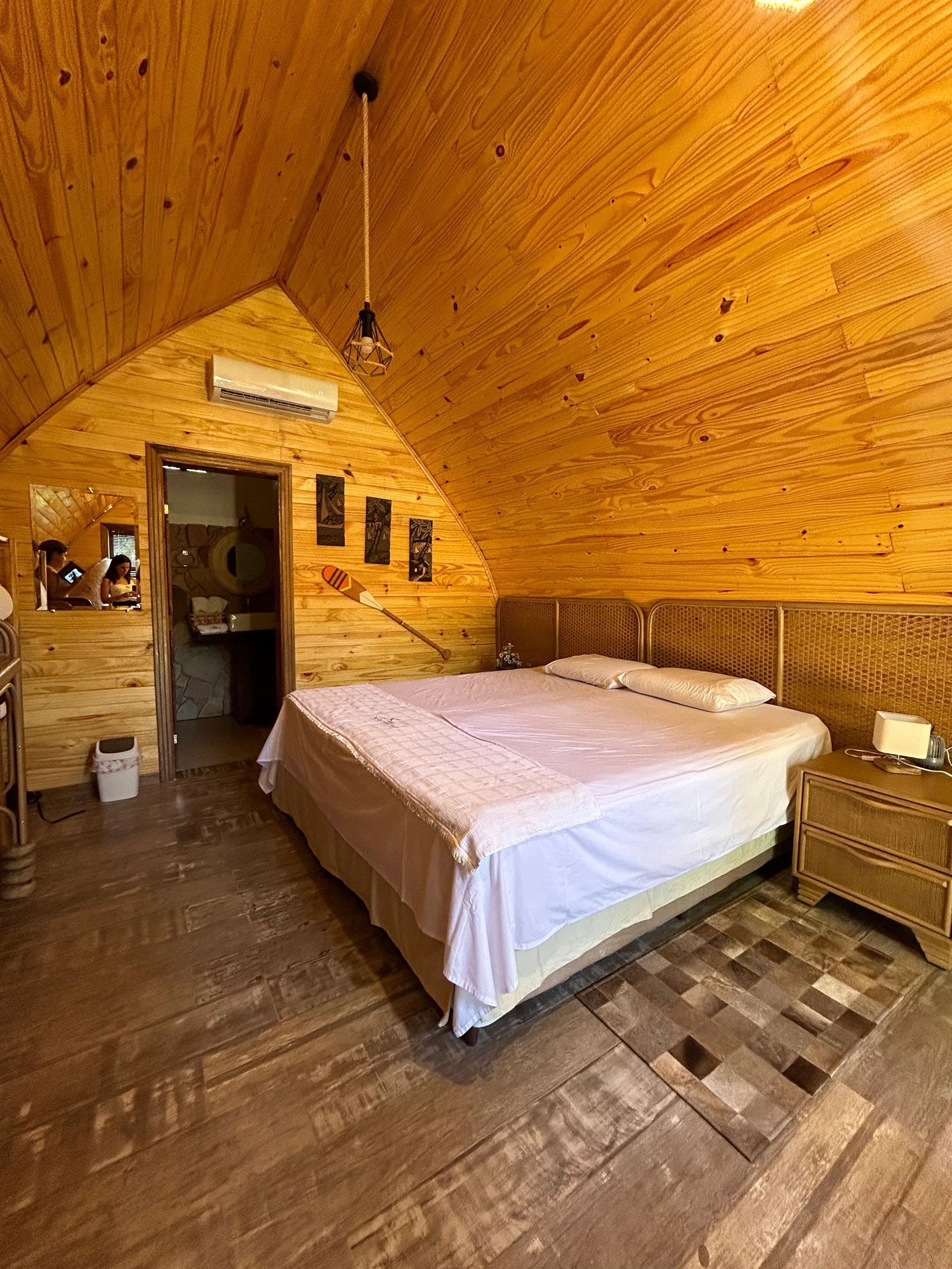 Un dormitorio con una cama king size y un techo de madera.