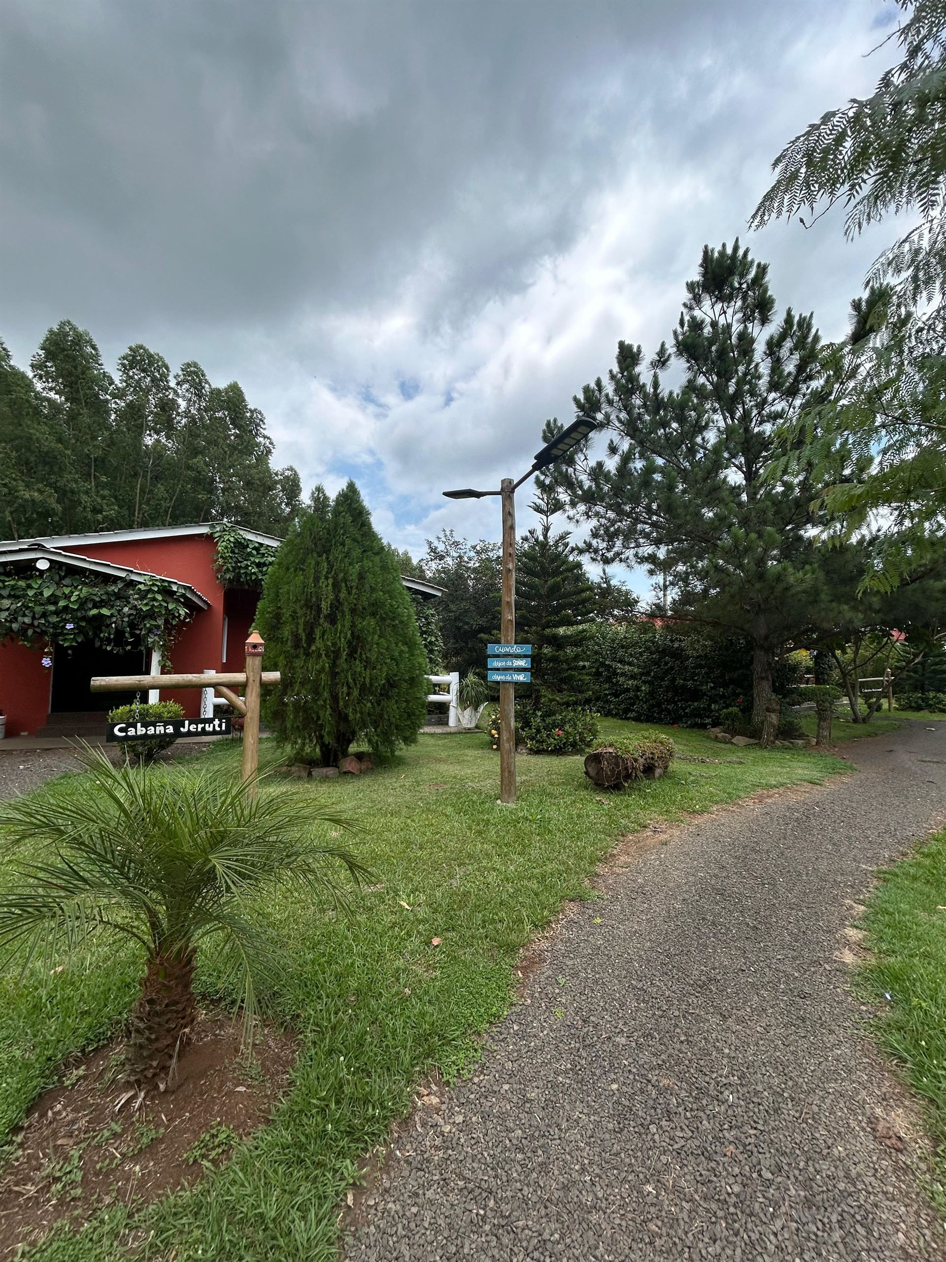 Un camino de tierra que conduce a una casa en medio de un campo.