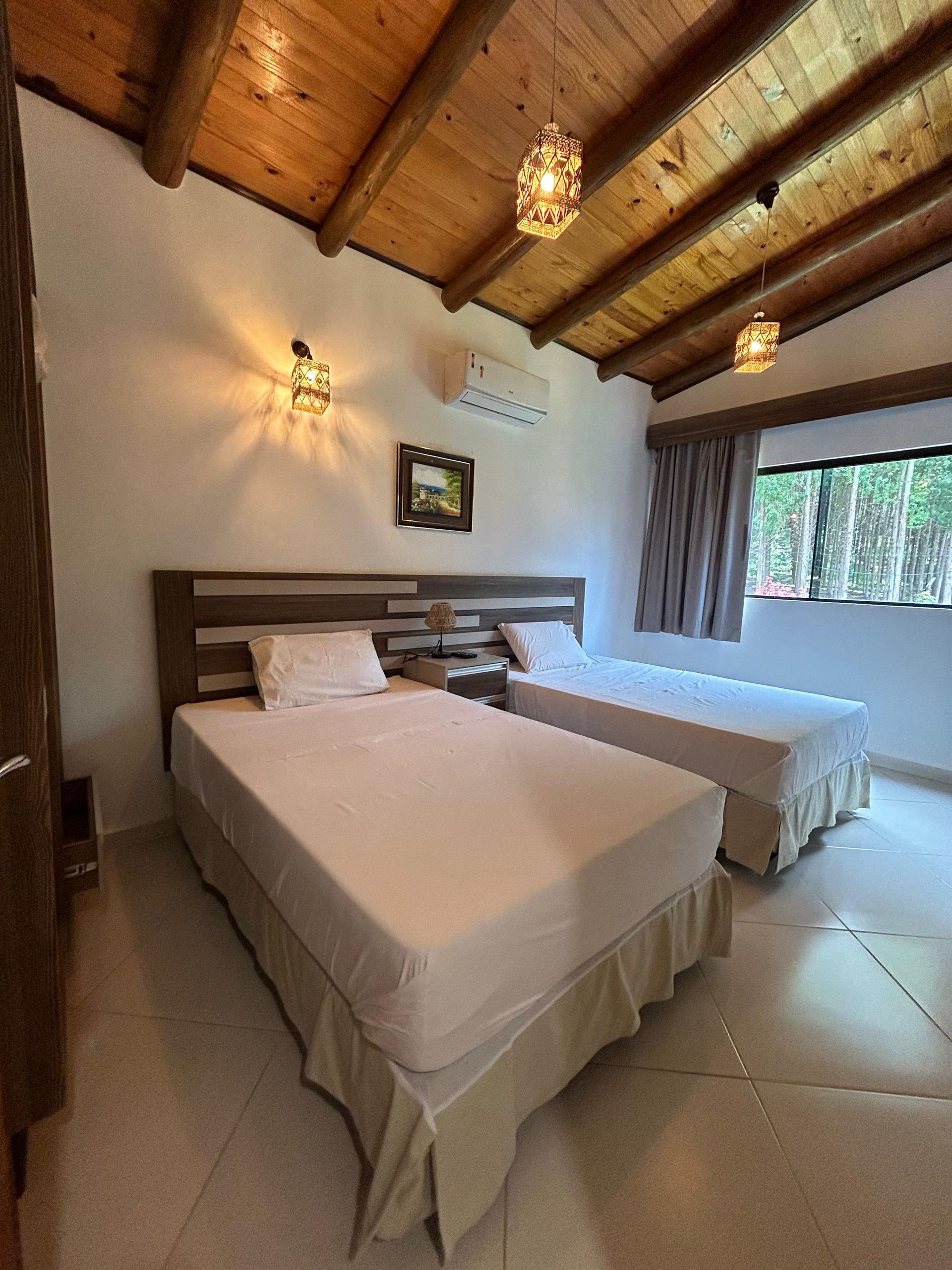 Un dormitorio con dos camas y techo de madera.