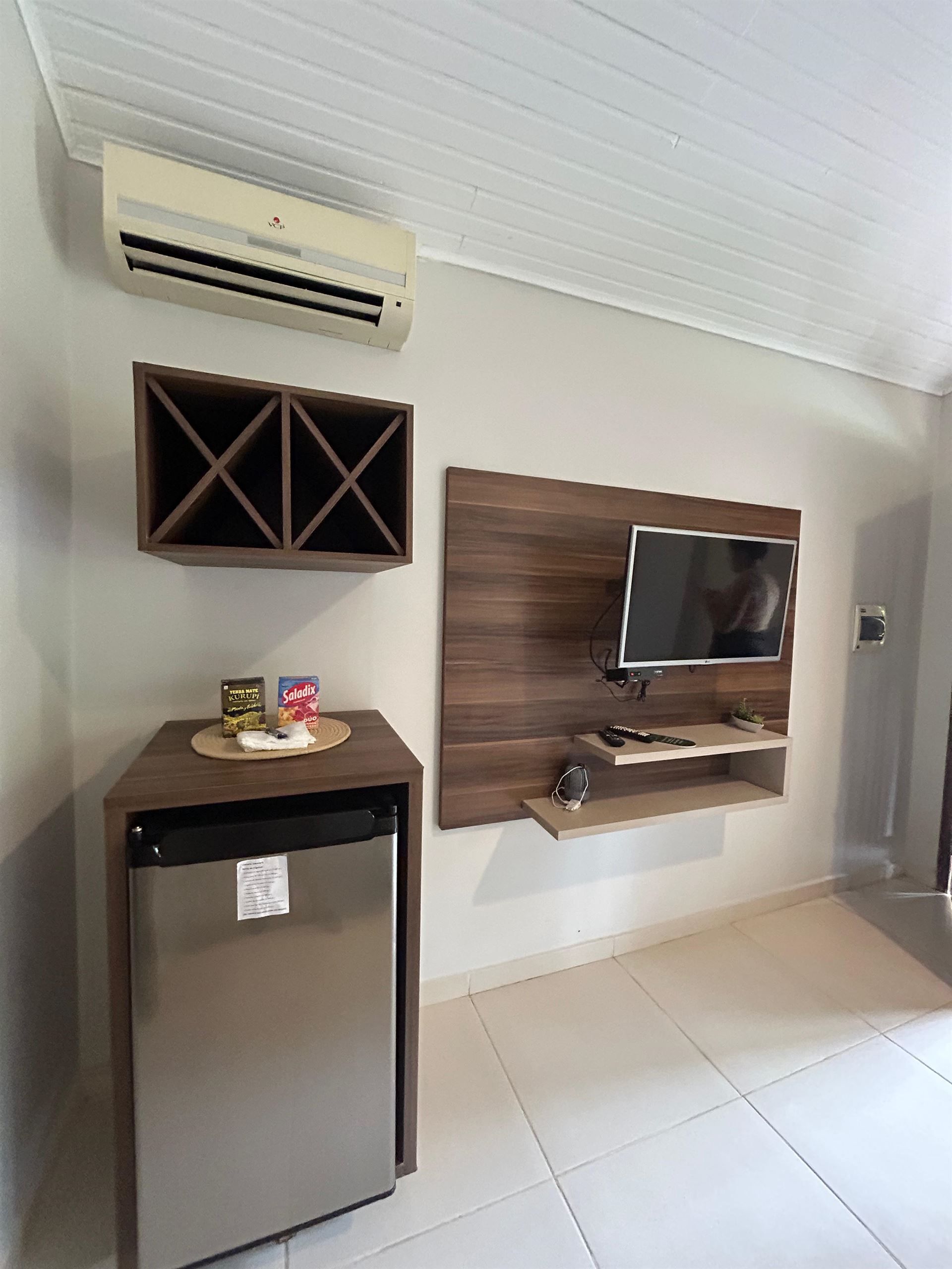 Una sala de estar con refrigerador, televisión y aire acondicionado.