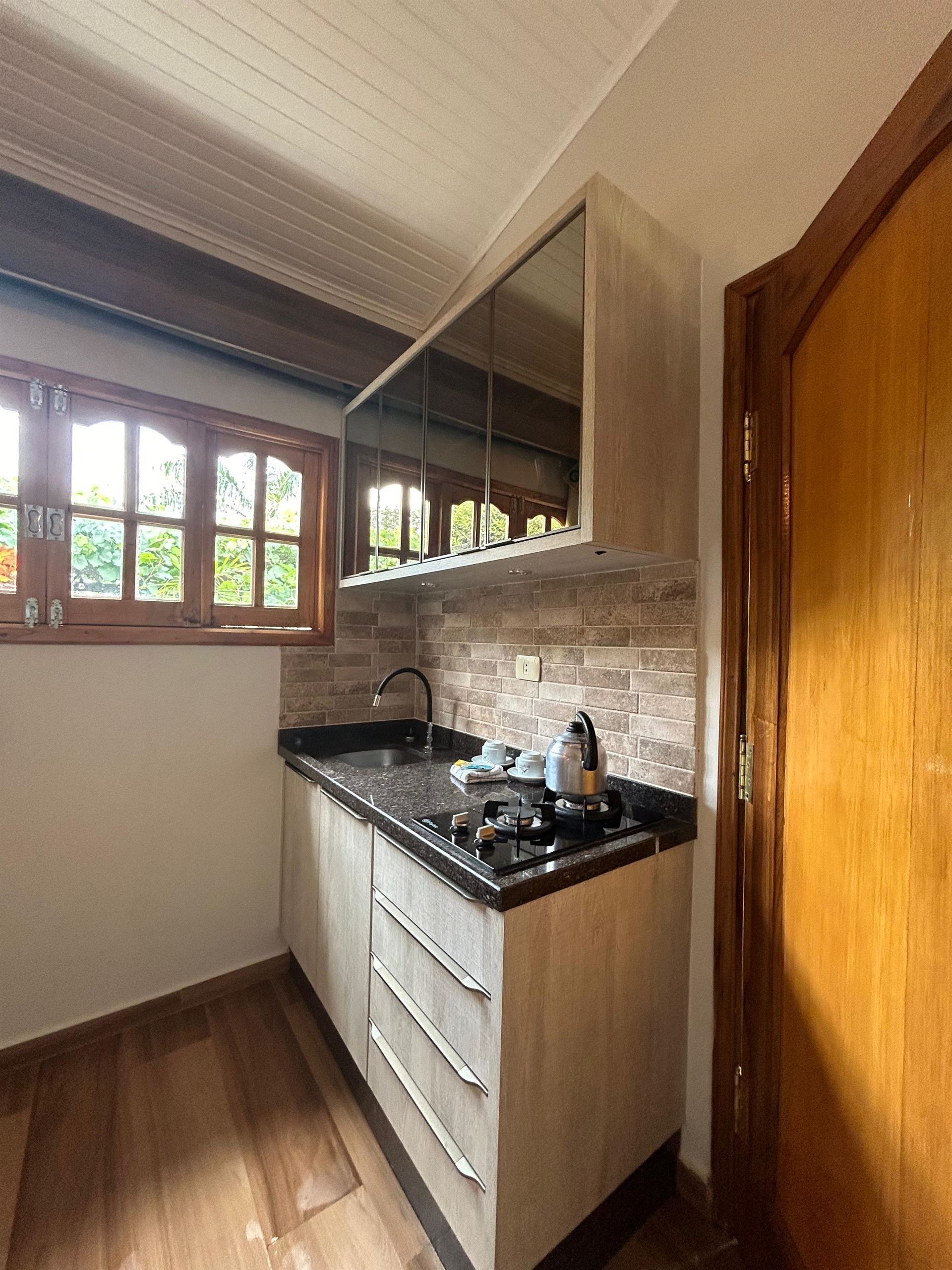 Una cocina con fregadero, estufa, gabinetes y una ventana.