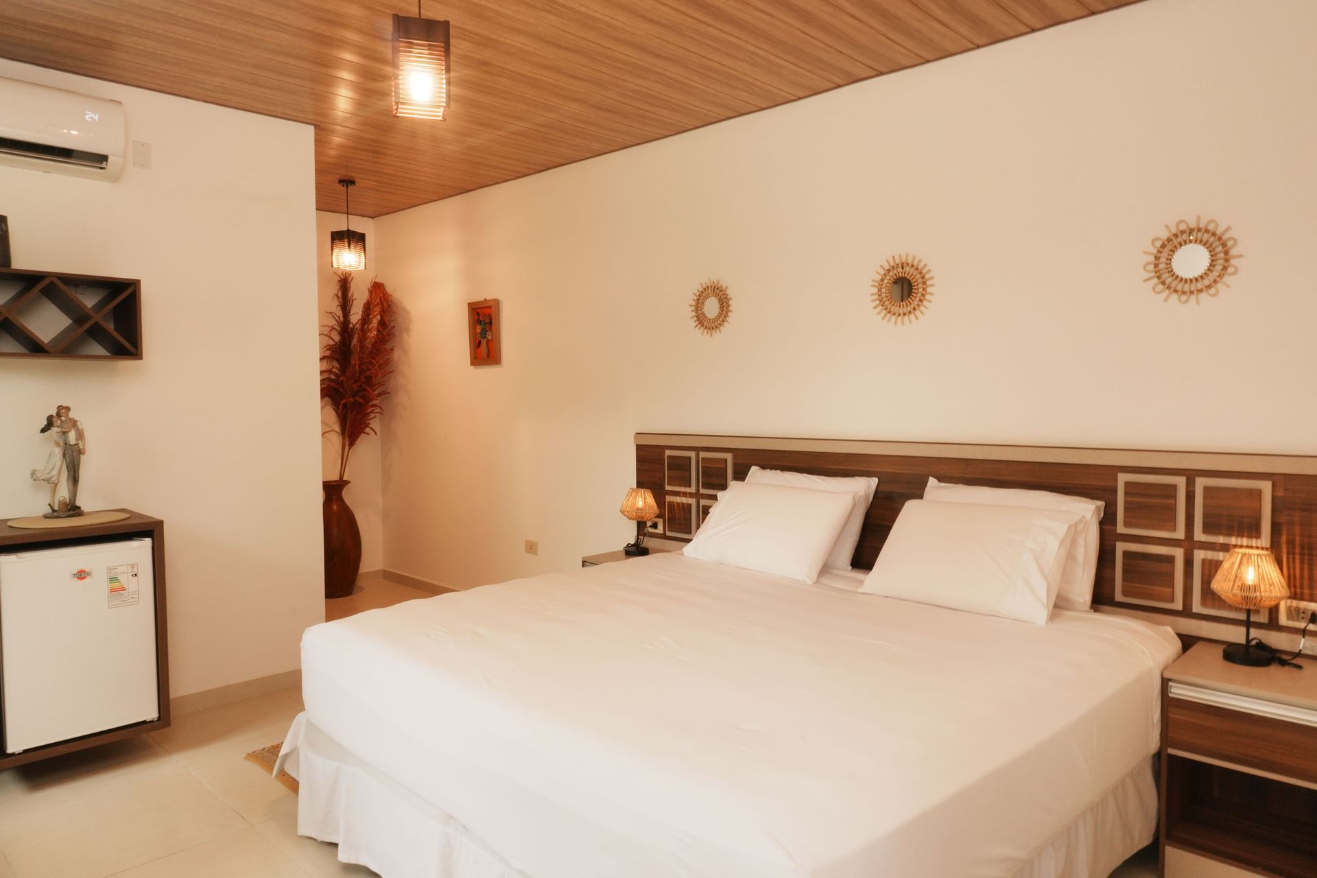 Un dormitorio con una cama grande y una lámpara en la mesita de noche.