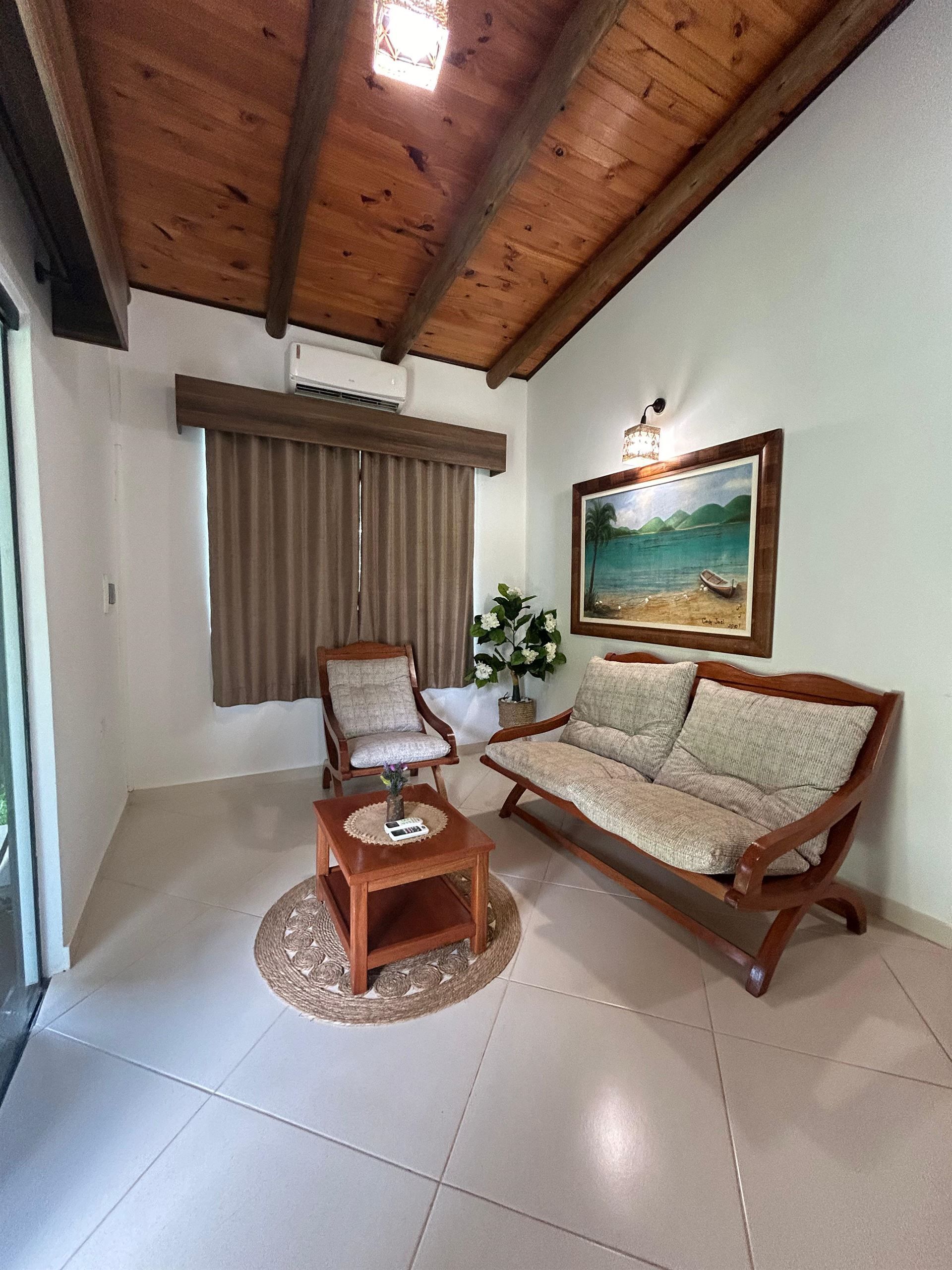 Una sala de estar con un sofá, sillas y una mesa.