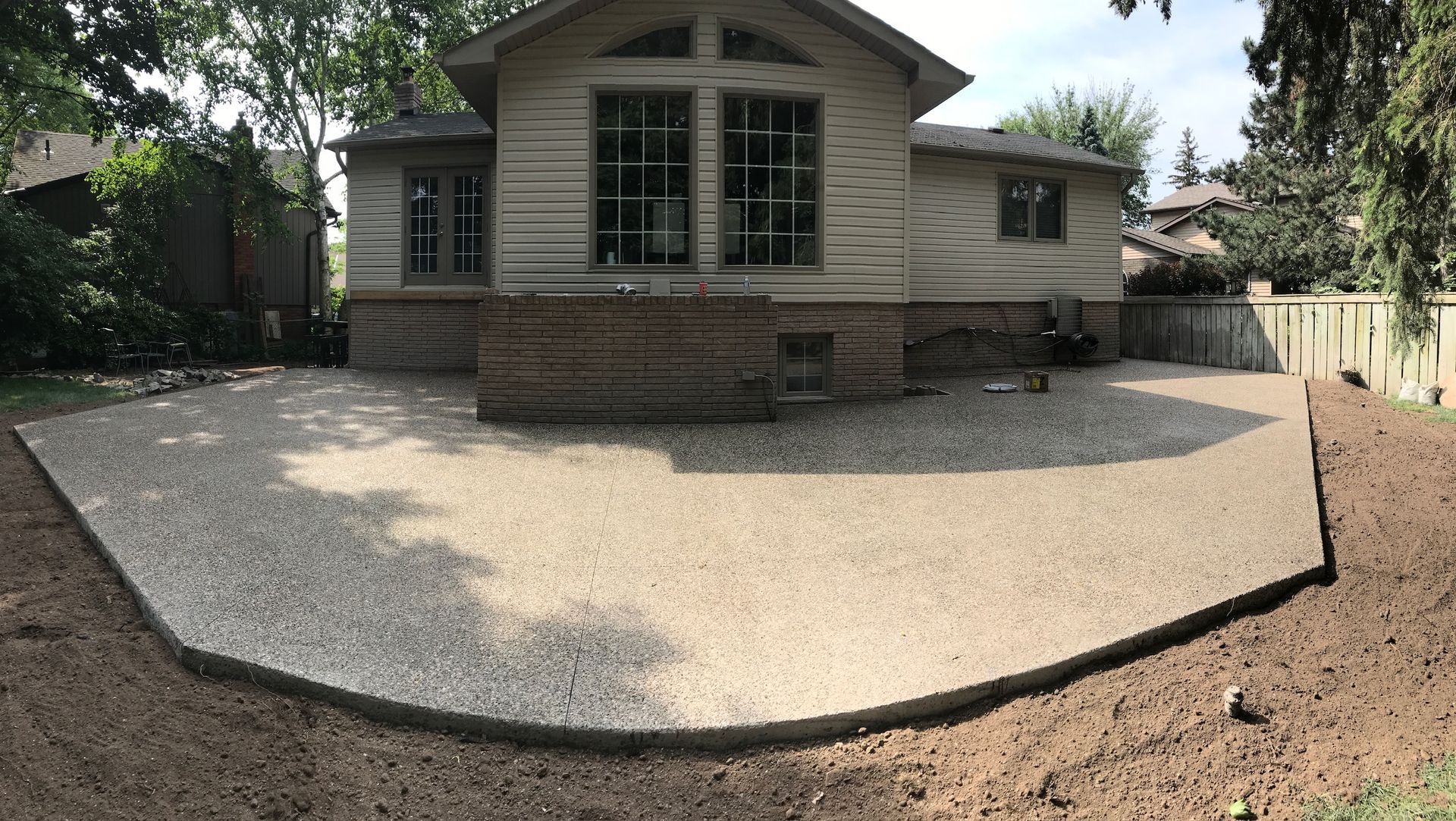 A house with a exposed aggreagete patio in front of it