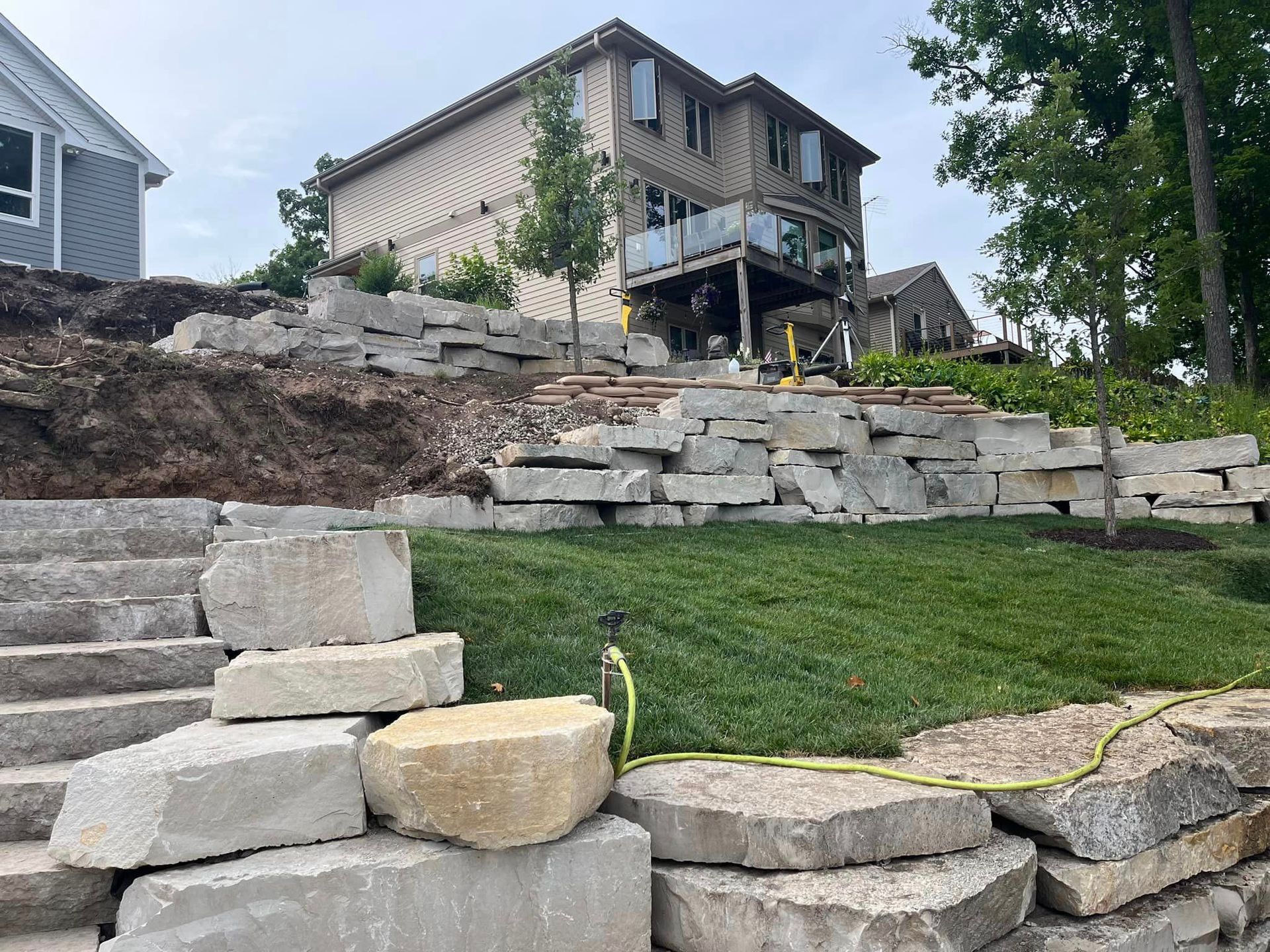 Hardscape project with natural stone leading to entrance of home
