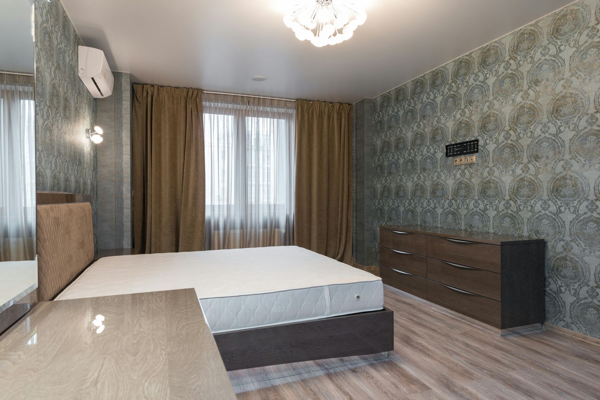 Bedroom with bed, dresser, window with curtains, and patterned wallpaper.